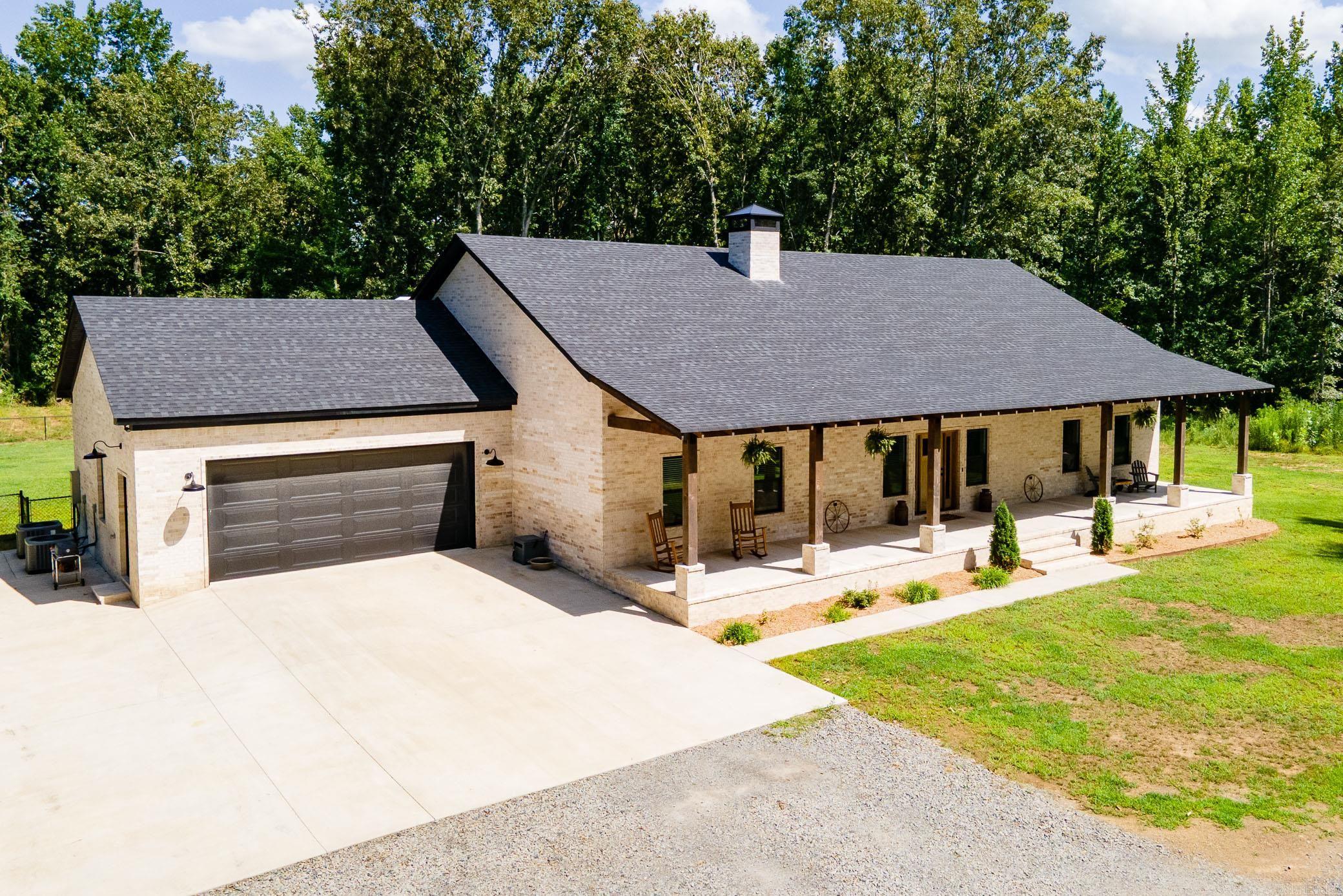 Experience the perfect blend of comfort, privacy, and country living in this beautiful 2,951 sq ft. custom home situated on 20 acres, just minutes from both Conway and Vilonia. This home features 3 bedrooms (a primary and junior suite) and 3.5 baths with a office. Inside you will find stained concrete floors, wood burning fire place, dual fuel range and a tank-less water heater. Built with 2x6 exterior walls, foam insulation, and a built in Generac generator, the home is designed for exceptional energy efficiency and year round comfort. Step outside to enjoy huge covered porches and mature oak trees. The property also includes a stocked pond, 30x45 shop and a gated pipe fence entrance creating the ideal setting for country living.