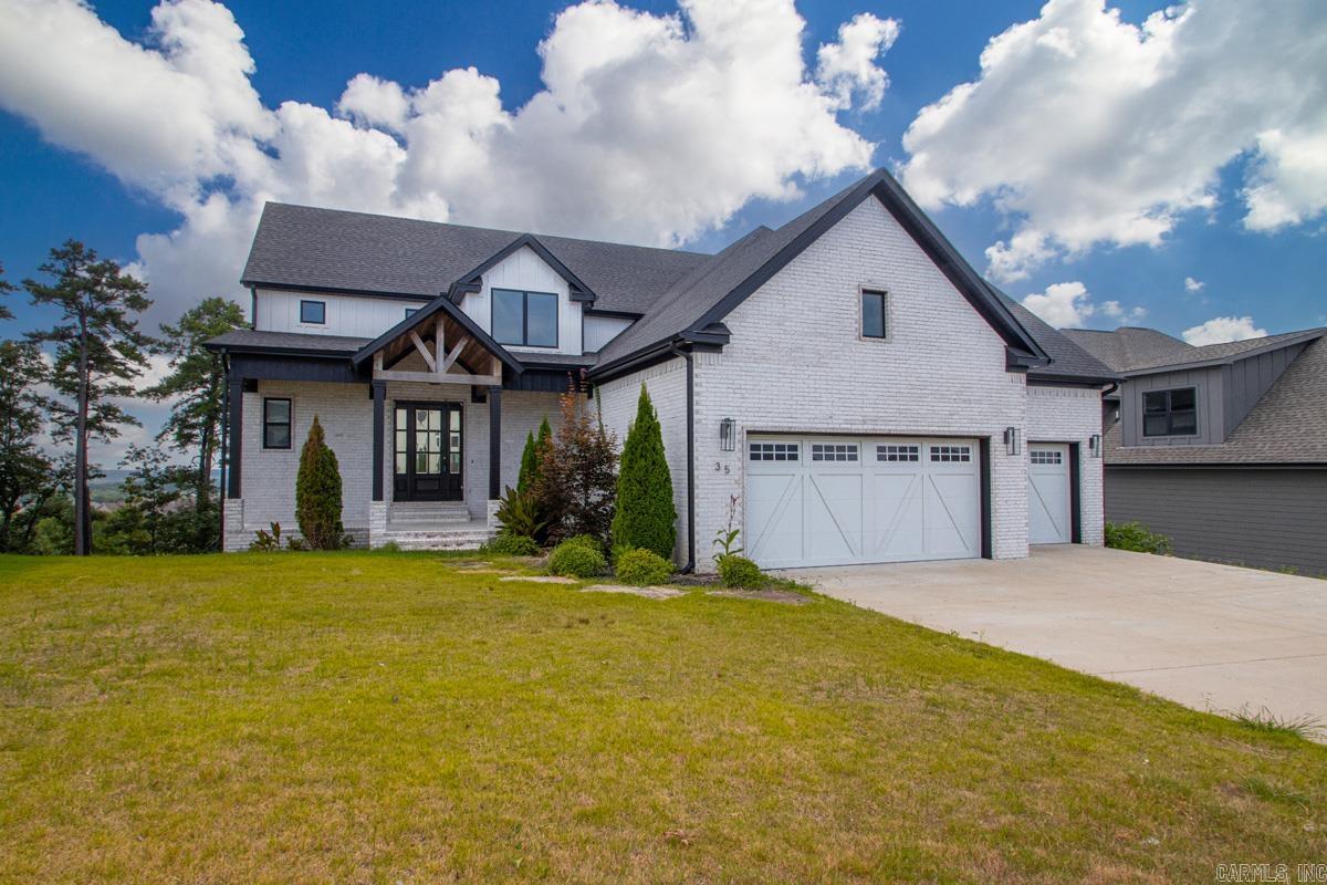 Experience refined living in this nearly new luxury home in the prestigious Falstone Subdivision of Chenal. Designed with exceptional craftsmanship, the open-concept floor plan showcases a dramatic vaulted tongue-and-groove ceiling, a striking gas fireplace, and elegant finishes throughout. The chef's kitchen features professional-grade appliances, solid surface countertops, and generous custom cabinetry. Enjoy seamless indoor-outdoor living on the covered deck with a soaring tongue-and-groove ceiling overlooking a private, wooded backdrop. The serene primary suite offers a spa-inspired bath with a freestanding soaking tub, oversized walk-in shower, double vanity, and an expansive custom closet that flows into the laundry room. A guest suite or executive office and full bath complete the main level. The walk-out lower level includes 2-3 additional bedrooms, two full baths, a game room, kitchenette, abundant storage, and a covered patio. A spacious 3-car garage completes this exceptional residence.