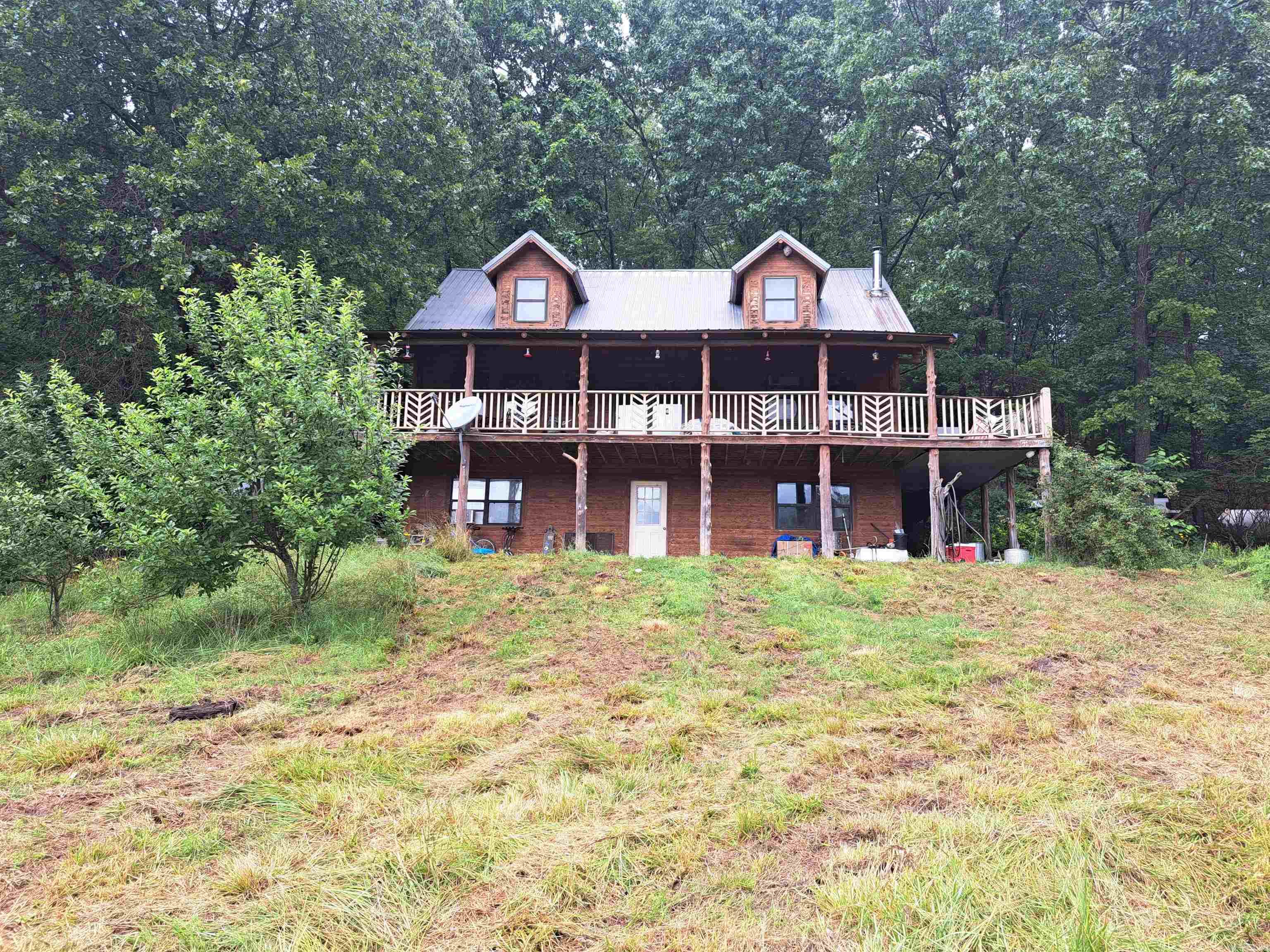 Discover the beauty and privacy of Ozark living on this stunning 148-acre property just minutes from Melbourne, Arkansas. Tucked away at the end of a long, tree-lined private drive, this secluded retreat features a 4-bedroom, 2.5-bath cedar log-style home with approximately 2,812 square feet of heated and cooled living space. Warm wood finishes, exposed beams, hardwood floors, and an open-concept design create a welcoming atmosphere, while the main-level primary suite adds convenience.  The finished basement offers additional living space, bedrooms, storage, and a wood-burning stove. A versatile 1,250-square-foot metal building includes living quarters, making it ideal for guests, extended family, a workshop, or hobby space.  The land is a beautiful mix of mature timber and open meadows with a seasonal creek, providing excellent opportunities for hunting, recreation, livestock, or simply enjoying the peaceful surroundings. Wildlife is abundant, and the property is conveniently located near the White River, Mountain View, and the Ozark National Forest.  Additional features include county road frontage, a whole-house 22KW generator, and exceptional privacy.   AGENTS SEE REMARKS