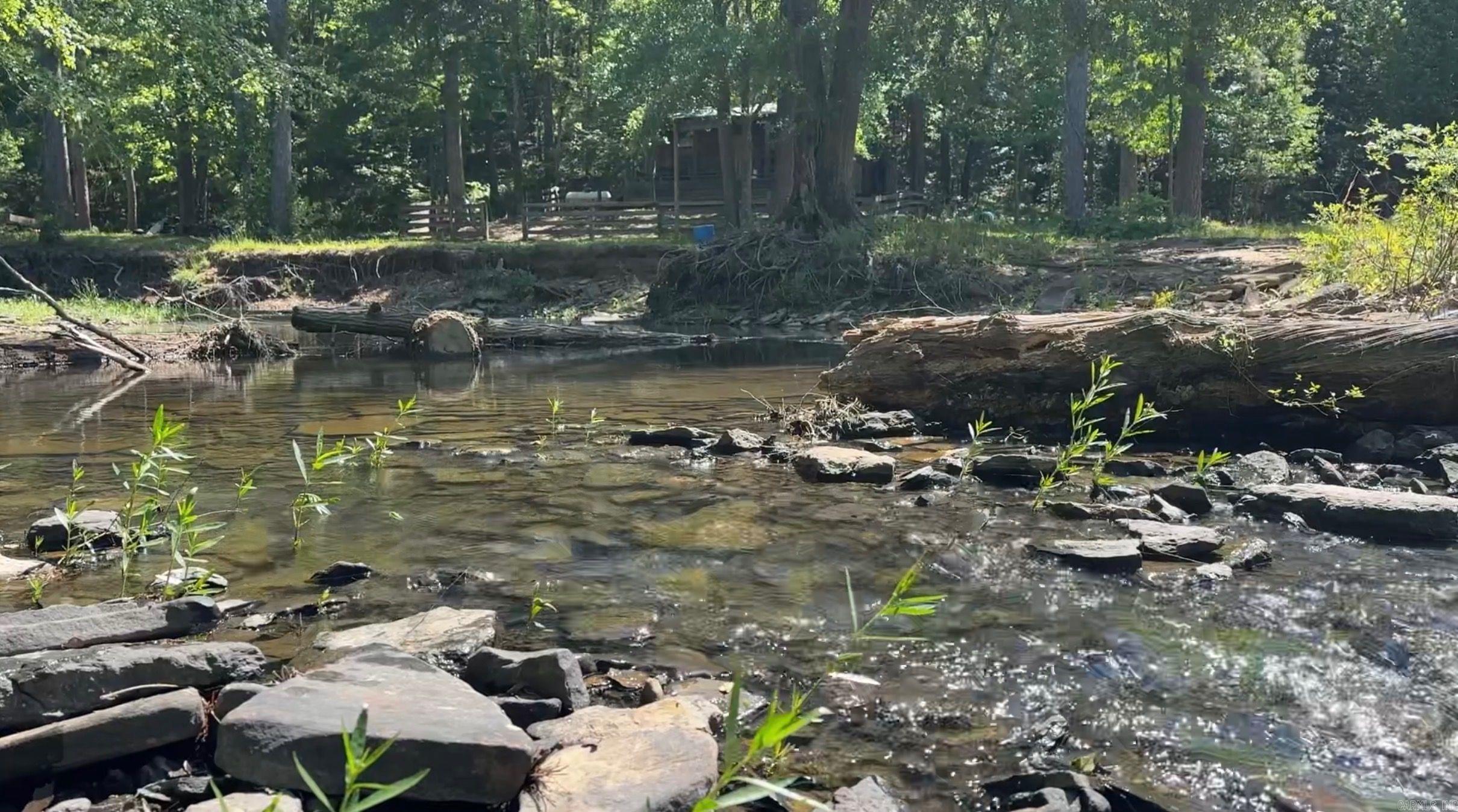 Big Creek Camp is the kind of property that’s becoming increasingly difficult to find — a large, private recreational tract with live water, mature hardwood timber, dramatic topography, and a cabin overlooking Big Creek itself.  Located in Cleburne County, Arkansas, this 172± acre property features over a mile of frontage along Big Creek. An established interior road system follows the creek through the property to the cabin tucked deep within the south end, creating a true secluded camp setting.  The timber is exceptional, with giant white oaks scattered throughout the tract along with abundant natural browse and muscadine vines that support strong deer and turkey populations. Hardwood ridges, creek bottoms, elevation changes, and natural travel corridors create outstanding wildlife habitat and hunting opportunities.  Interior roads allow easy access across nearly the entire property by truck or side-by-side, while a well-maintained all-weather road leads directly to the cabin. Additional features include two ridge-top wildlife openings, a pond, and several wet weather waterfalls that add even more character to this unique retreat.