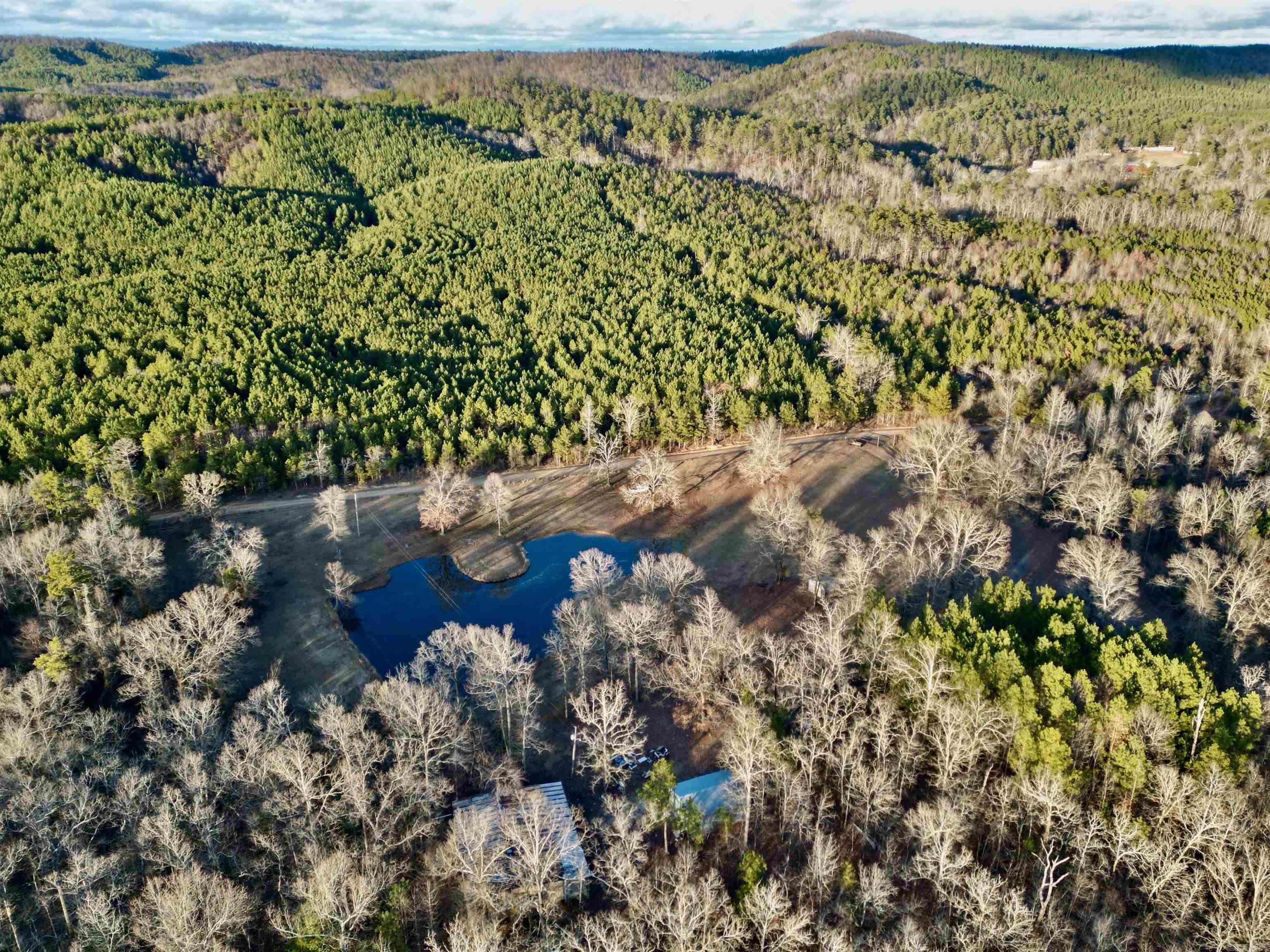 Nestled on 40 acres of unspoiled wilderness, this fenced and gated sanctuary embodies the ultimate hunter's paradise. A picturesque pond glistens amidst the landscape, complemented by two expansive shops, water and electric on-site and a robust year-round creek that meanders through the property, accentuating a thoughtfully designed trail system. Offering county road frontage and perfect sites for constructing your dream home, this private haven teems with abundant wildlife, inviting you to revel in the serenity and untamed beauty of this country property.