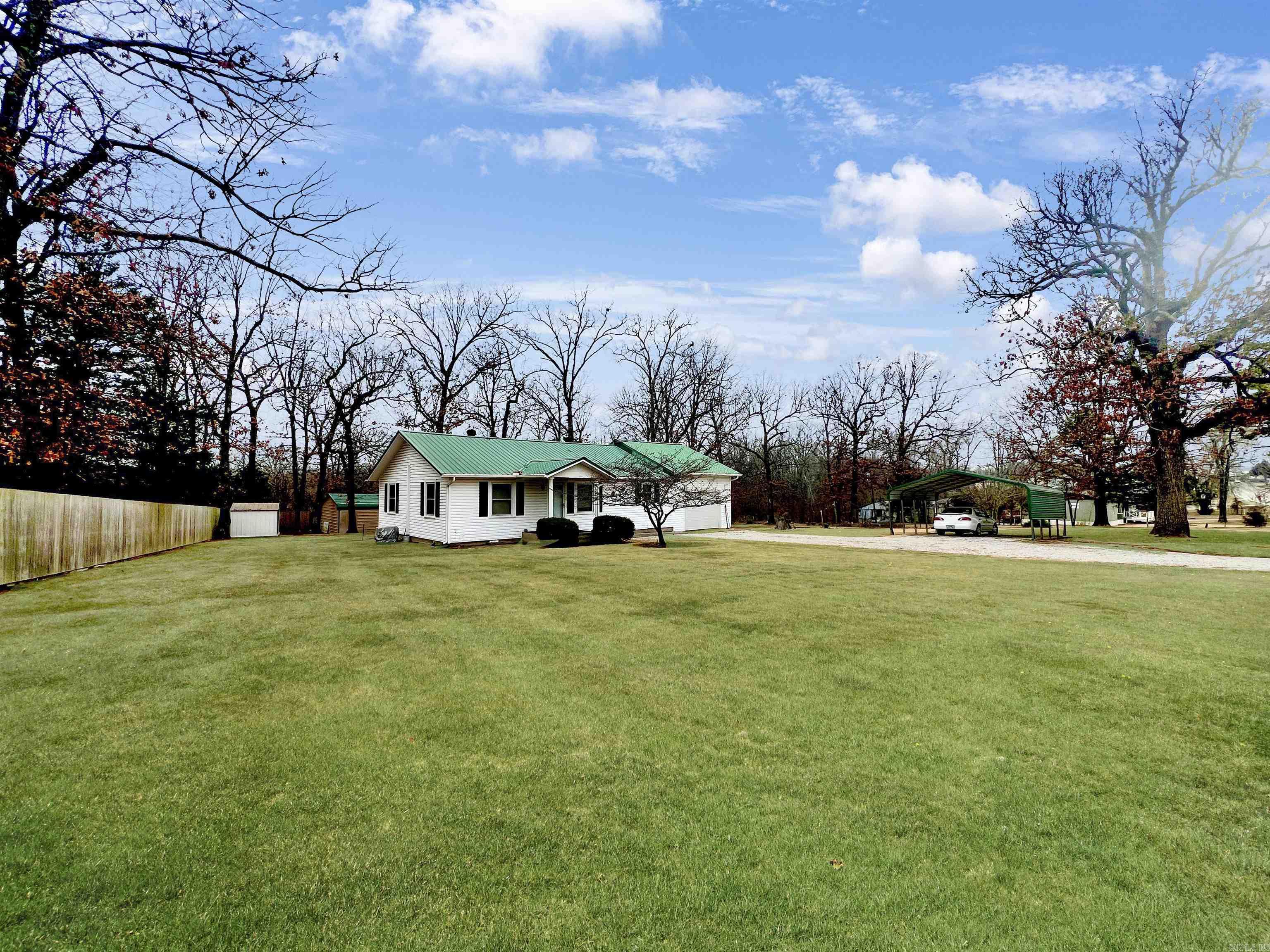 Great well-maintained home with park-like unrestricted property. This 4-bedroom home is conveniently close to shopping, the hospital, schools and businesses, just outside city limits on 1 unrestricted acre. Plenty of storage, great kitchen layout and ready to move in! Fantastic screened-in back deck to watch the wildlife and an open deck to barbecue. Flowers throughout the property and gardens are ready for planting. Two outbuildings for more storage. 2 Car Carport in addition to oversized 1 Car garage. Fiber optic Internet available. Newer metal roof, Regularly serviced HVAC, Privacy fence on two sides only 3 years old. Large Propane Tank. Fourth bedroom is above the garage. Measurements and square footage are approximate.