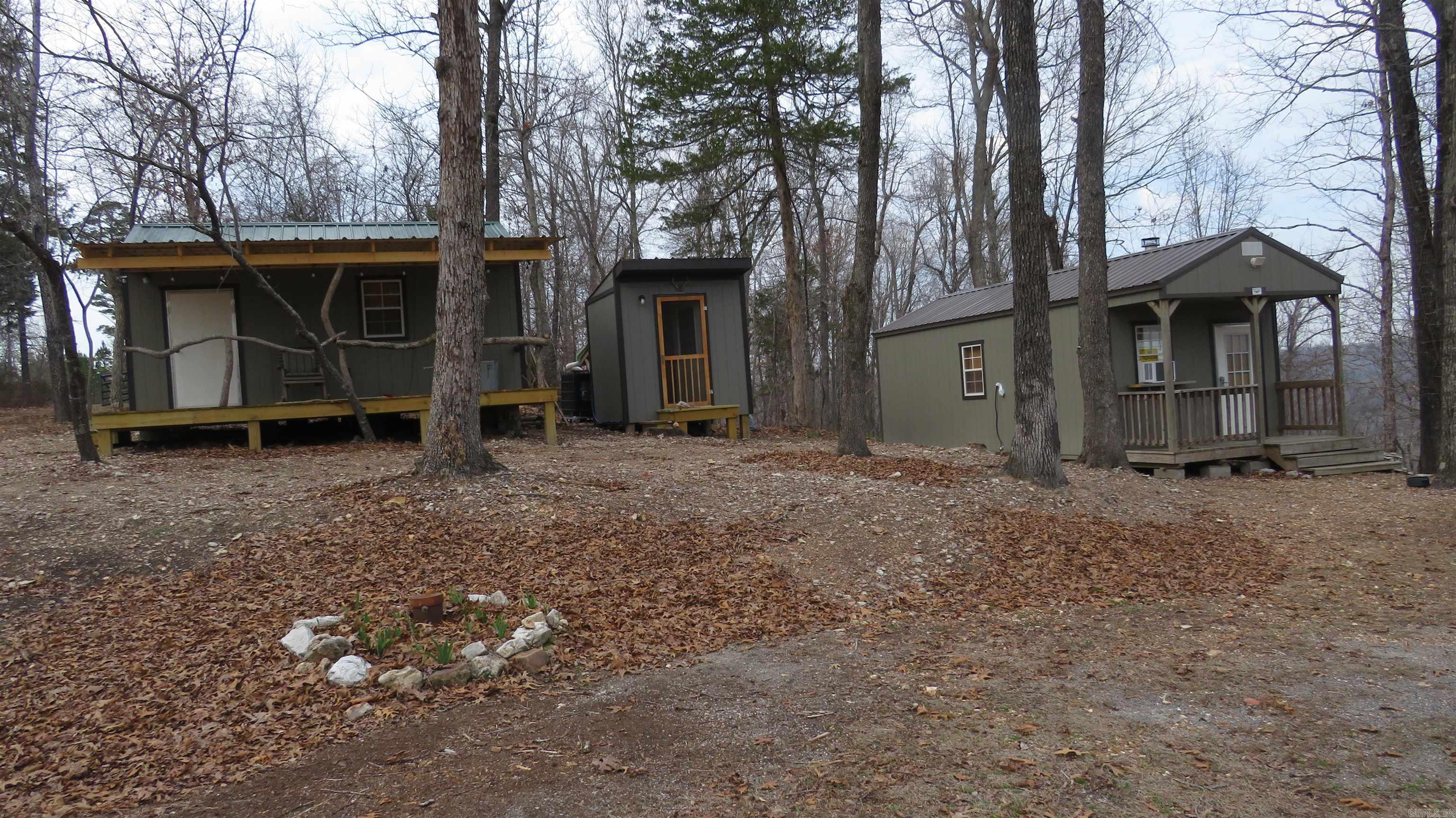 10 Acres Bordering The Sylamore National Forest – Turnkey Off Grid Cabin VRBO Escape to the Ozarks with this rare 10-acre property surrounded by The Sylamore National Forest on two sides, just minutes from Roasting Ear Creek. Private, peaceful, and fully set up as a successful VRBO-style getaway, this property is ideal for recreation, investment, or a personal retreat. The land features two charming Bald Eagle Barns: Main Barn – thoughtfully converted into a kitchen and bedroom Bunkhouse Barn – perfect for guests, with a spacious front deck for relaxing and taking in the scenery A separate bath house includes a sink, toilet, and walk-in shower, offering comfort while maintaining the rustic outdoor experience.  Additional highlights include:  Outside fire pit for evenings under the stars Excellent deer, turkey, and small game hunting right on the property, Private well already in place Secluded setting with direct access to thousands of acres of public land  Whether you’re looking for a turnkey short-term rental, a hunting basecamp, or a quiet off-grid-style escape, this unique property offers endless possibilities in a highly sought-after natural setting all for only 149,900.