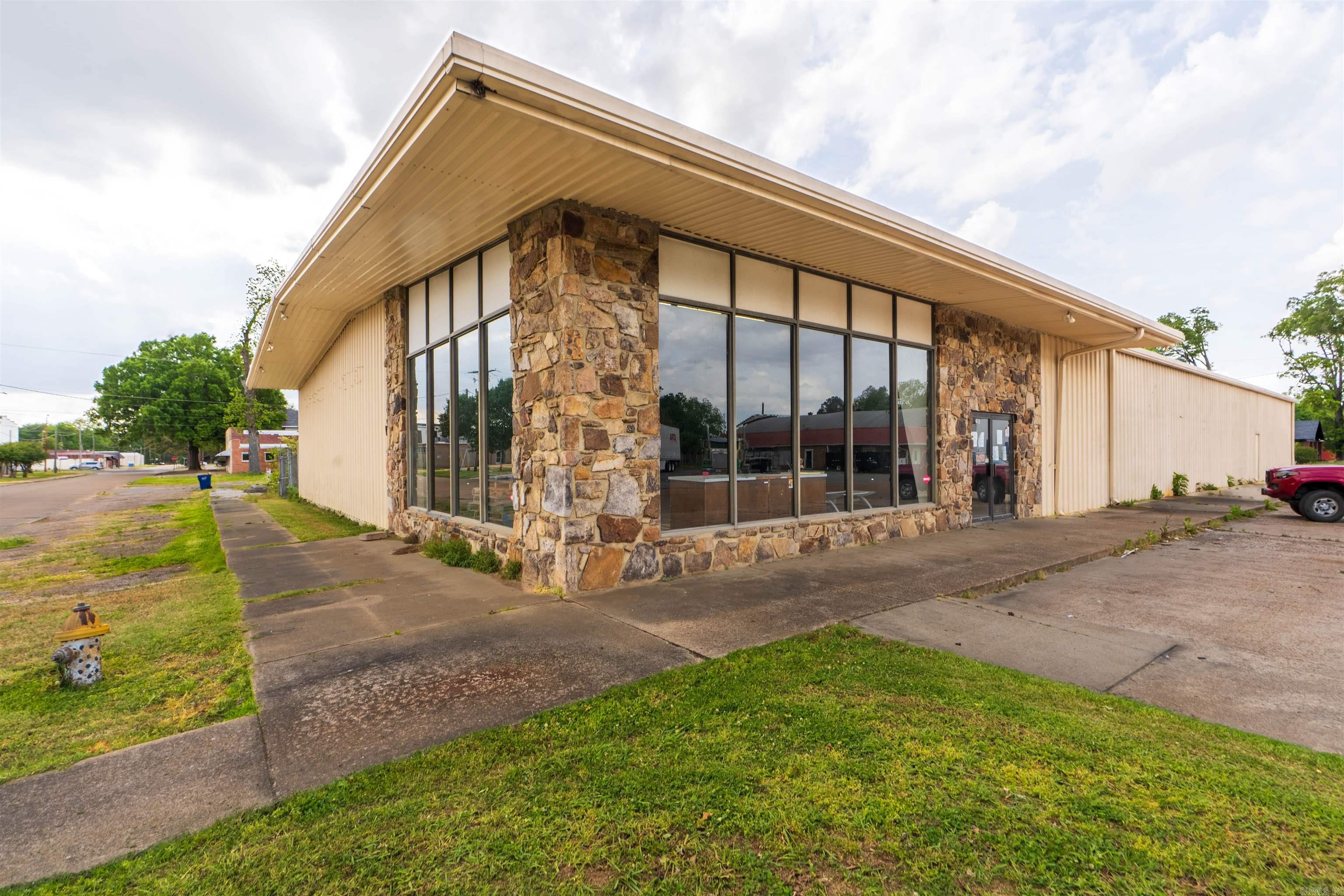 Positioned on a highly visible corner at 201 N New Orleans Avenue, this expansive 10,500± square foot commercial building offers exceptional space and flexibility for a wide range of uses. Situated on approximately 0.46 acres, the property features a large open-span interior with high ceilings, making it ideal for retail, warehouse, distribution, event space, or redevelopment.  The building includes multiple access points, a loading dock for convenient deliveries, and a mix of open floor space along with office and storage areas. The front façade offers strong street presence with large display windows, while the rear and side areas provide additional access and functionality.  Inside, the structure showcases steel framing, concrete floors, and ample lighting throughout. While the property will benefit from updates and repairs, it presents a strong value-add opportunity for investors or owner-users looking to customize the space to fit their needs.  Located in the heart of Brinkley with easy access to major roadways, this property combines size, visibility, and potential at an attractive price point.