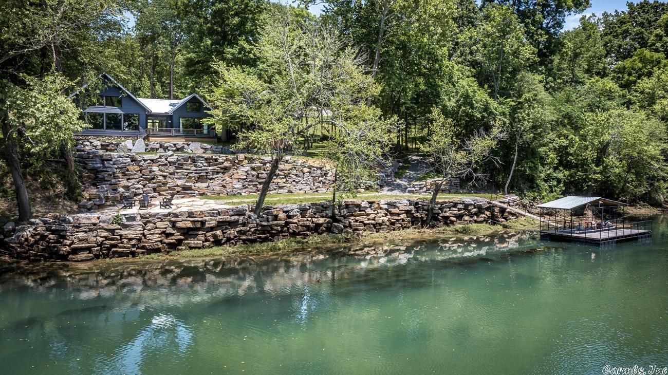 RIVER FRONT HOME IN PRIMROSE CREEK, COMPLETELY FURNISHED! Newly con-structed in 2021 by Gary Cresswell. Seller has carefully chosen every item and thoughtfully laid out every area on this property. 2 Bedrooms, bunk room and an art studio that could be used as 3rd bedroom.  Amazing rock work along the river bank, screened porch w/swinging bed, boat dock, all great for entertaining family & friends.  Listing includes downstream lot. Community pool & dock too!  Gated entrance.
