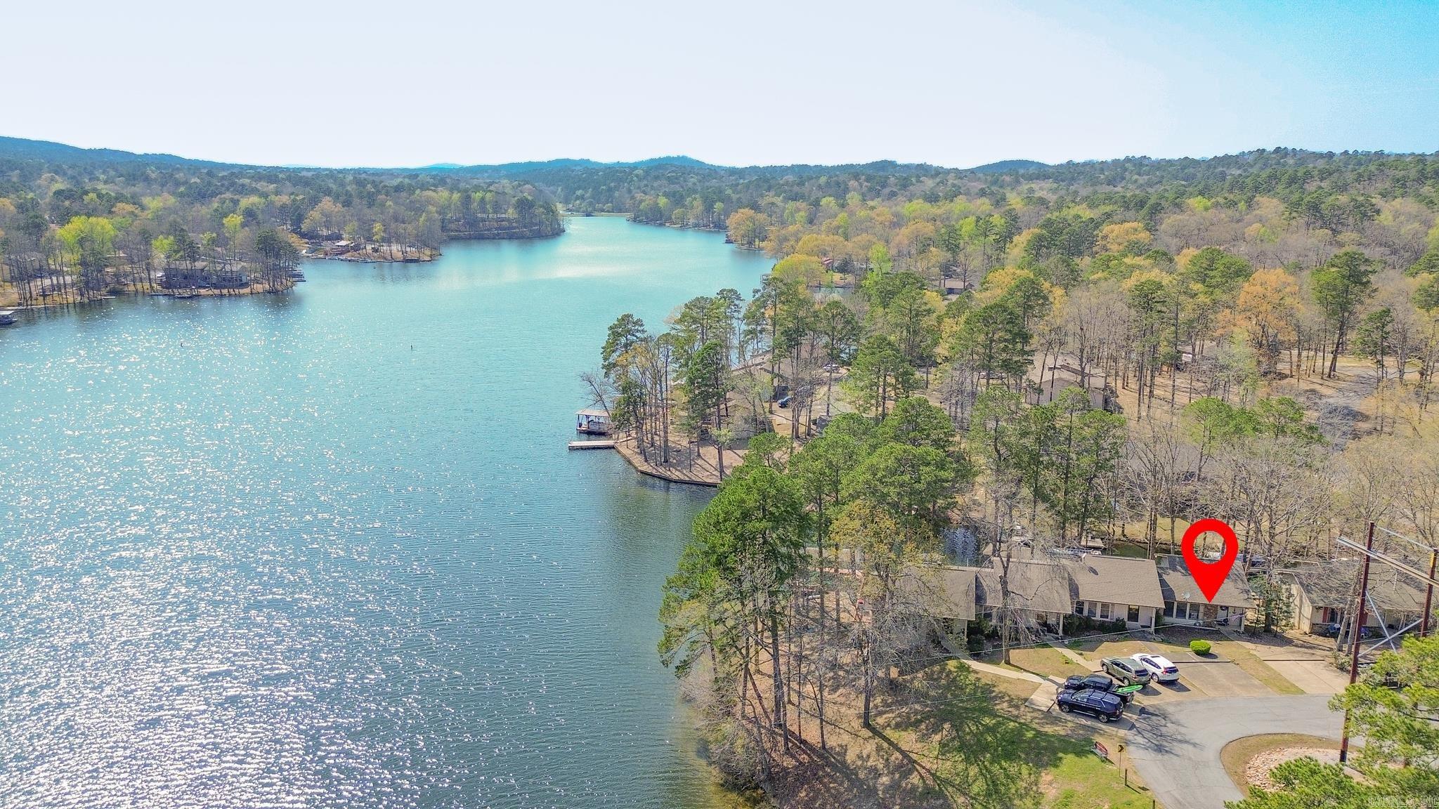 Wake up to stunning WATERFRONT views on beautiful Lake DeSoto! This fully furnished 3-bedroom END-UNIT offers the perfect mix of relaxation, recreation, and income potential with a proven successful short-term rental history. Enjoy incredible sunsets from your private back deck or lower patio, or walk down to your own boat/swim dock and head straight onto the lake. The sale even includes two kayaks with all the gear, making it a truly turnkey lake getaway. Inside you'll find an updated kitchen with granite countertops and new appliances, perfect for entertaining after a day on the water. New LVP flooring and carpet. The main-level also includes the primary bedroom with deck access and a full bath, while the lower level offers two additional bedrooms and full bath—ideal for family or guests. An oversized laundry/storage/owner’s room provides space for personal belongings. The home is fully equipped for vacation rentals, including extra linens, dishes, silverware, cookware, and everything needed for guests, allowing income from day one. Hot Springs Village has a $2000 new owner buy-in fee.