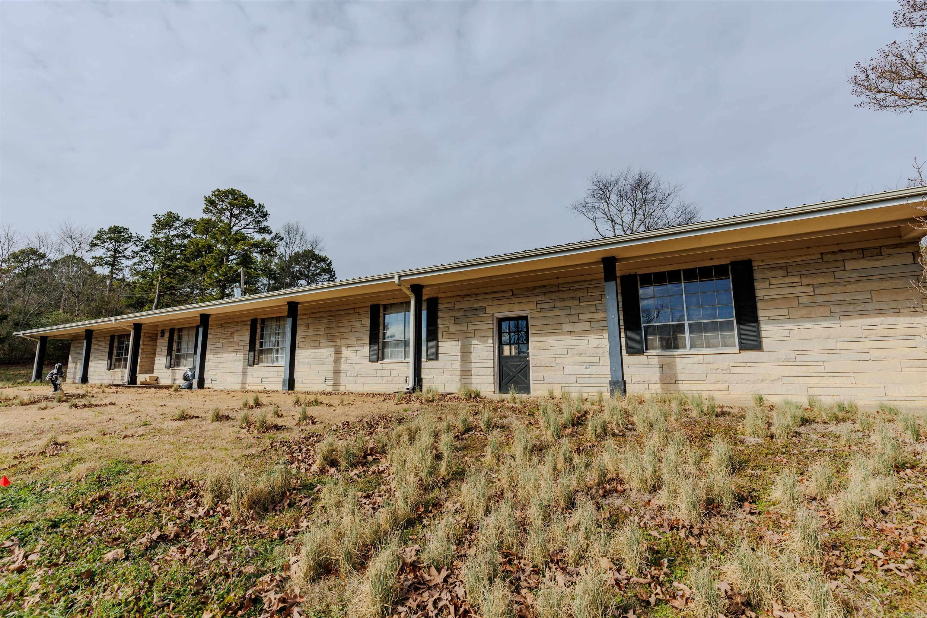 Large 4 bedroom, 3 full bath, ledge stone ranch home on 8.59 acres with a spectacular view! Long, paved driveway off Hwy 64, 3.5 miles from downtown Morrilton and 20 mins to downtown Conway.  Large kitchen with great potential! Super large bonus room for kids or adults to enjoy! Open great room with fireplace that attaches to kitchen. Full length sun room with hot tub, utility sink and space for any activity! Whole house generator, metal roof, large double car garage & storage, fenced back yard, well and chicken coop!  Lots of potential and ability for multi generational living.  Master suite and bath on one end - 3 bedrooms and 2 baths on the other end. Pasture for horses and livestock and hunting ability on wooded section of property which includes a seasonal creek. Definitely need updates and repair/remodel of floors, master bedroom and bath, and laundry room (new flooring in boxes is included). Bring your vision and skills and make this into the grand house it can be!!   House will be sold "AS-IS, WHERE-IS" as price reflects. New owners can subdivide and sell lower portions of land and still have large beautiful yard with view!   *** Agents - please see remarks ***