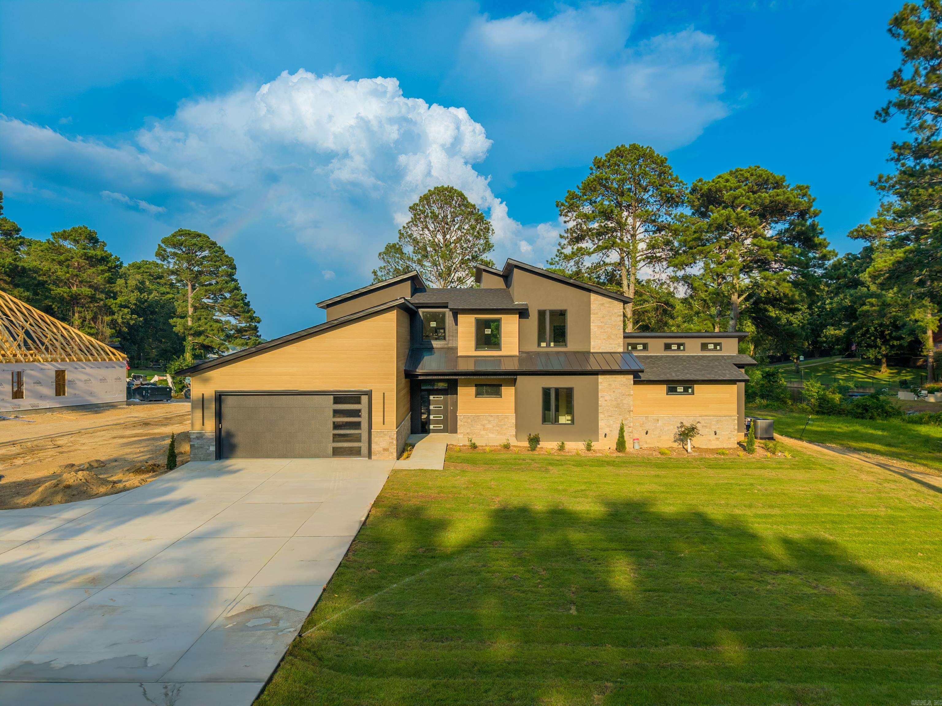 Experience luxury lake living in this stunning brand-new contemporary home on Lake Hamilton! Offering approximately 3,500 sq. ft., this exceptional waterfront retreat features 5 bedrooms, 3 bathrooms, and an open-concept floor plan designed for both entertaining and everyday living. Soaring ceilings, expansive windows, and panoramic lake views fill the home with natural light. The designer kitchen boasts premium appliances, custom cabinetry, high-end finishes, and an oversized island that flows seamlessly into the spacious living and dining areas. The primary suite offers breathtaking water views, a spa-inspired bath, and a large walk-in closet. Situated on a level lot with approximately 103 feet of pristine Lake Hamilton frontage, the outdoor living is second to none with an in-ground pool, fully equipped outdoor kitchen, expansive patio, and spectacular sunset views. A private two-stall boat dock provides effortless access to boating, fishing, and watersports. This turnkey home offers the perfect blend of modern design, luxury finishes, and the ultimate Lake Hamilton lifestyle.