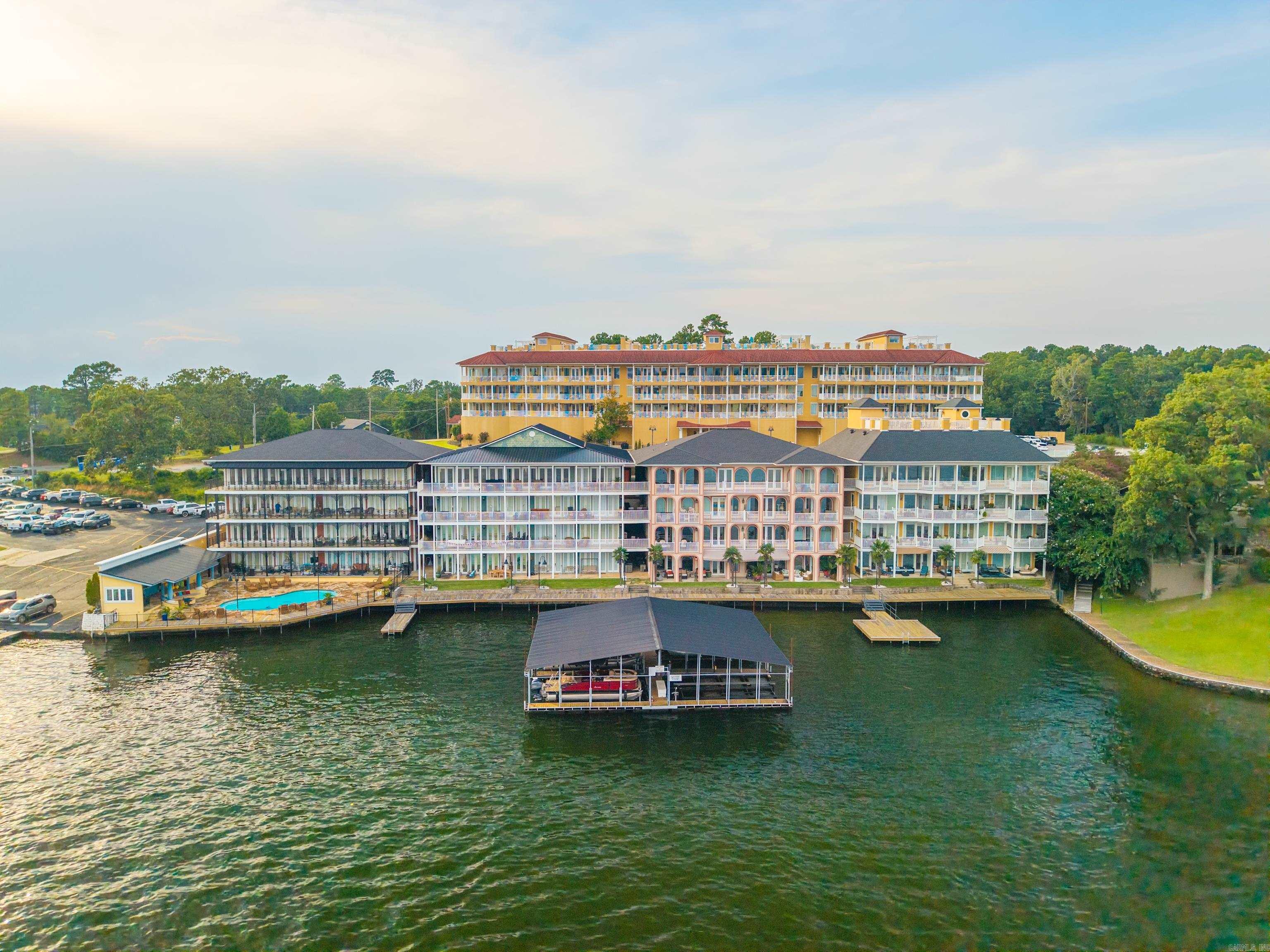Experience effortless lake side living in this spacious 2BR, 2 BA second floor, CORNER unit condo offering over 1,600 square feet at Fiesta Bay, a premier gated community on Lake Hamilton. Positioned to capture natural light, this residence showcases water views from the living areas and the primary suite. The open concept creates a seamless flow between the kitchen, dining, and living areas, perfect for everyday living and entertaining. Features all new blinds, paint, fixtures, mirrors, fencing, electrical fixtures, tv's and mirrors, fully furnished, appliances included! Step outside to the spacious covered patio, an ideal space to unwind, dine, or simply take in the peaceful sights of boats passing along. This sought-after waterfront community offers residence private dock access and resort style pool.