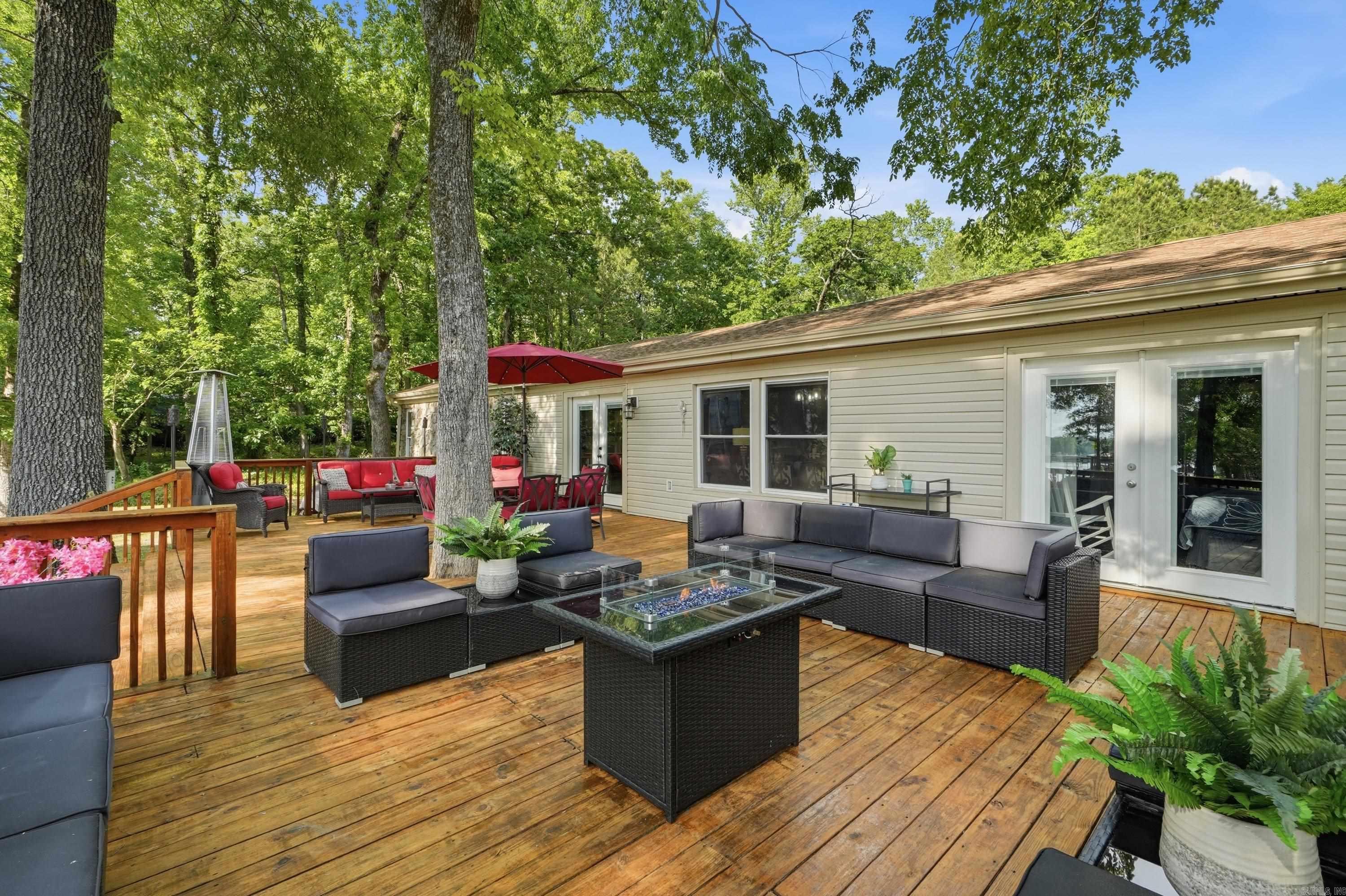 Experience luxury lakefront living on Lake Hamilton in Hot Springs, Arkansas. Completely remodeled with high-end finishes and thoughtfully designed. This stunning waterfront home offers 2,442 square feet of beautifully updated living space with four bedrooms, three and a half bathrooms, and a versatile flex room to fit your lifestyle needs. This exceptional property features two spacious primary suites, each with private en-suite bathrooms, creating the perfect setup for guests, multigenerational living, or a luxury vacation retreat. Inside, you’ll find modern finishes, an inviting layout, and spaces designed for both comfort and entertaining. Step outside to the expansive lakeside deck where family and friends can gather, relax, and enjoy breathtaking sunsets on Lake Hamilton. Whether hosting summer cookouts, sipping morning coffee, or unwinding after a day on the water, this outdoor space is made for making memories. With no HOA fees and no restrictions, this rare luxury property offers endless possibilities as a full-time residence or vacation home. Enjoy the freedom of lake living without limitations in one of Hot Springs’ most desirable waterfront locations.