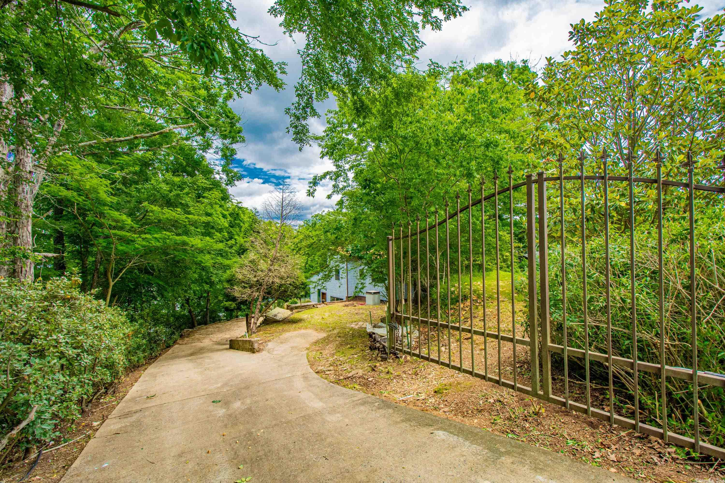 This beautifully updated home is the perfect gated lake retreat.  LVP flooring throughout the living areas.  On the main level you will enter to a large living room with vaulted ceilings, electric fire place with black shiplap wrapped chimney, new windows, and gorgeous fixtures.  Kitchen is updated with new cabinets and counter tops and lighting.  Eat in kitchen and half bath with new vanity and fixtures. Heading upstairs you will find modern cable and metal stair railings.  You will find Laundry closet, 3 bedrooms and 2 bathrooms.  The main bathroom features a large walk in shower.  The primary bedroom has its own bathroom with double vanity and jetted tub.  From the living room walk out new sliding patio doors to the large deck.  From the deck you can walk down the concrete path to the covered dock.  Roof was new in fall of 2020. Paved drive and automatic private gate (2020). This lake retreat is a little piece of heaven.