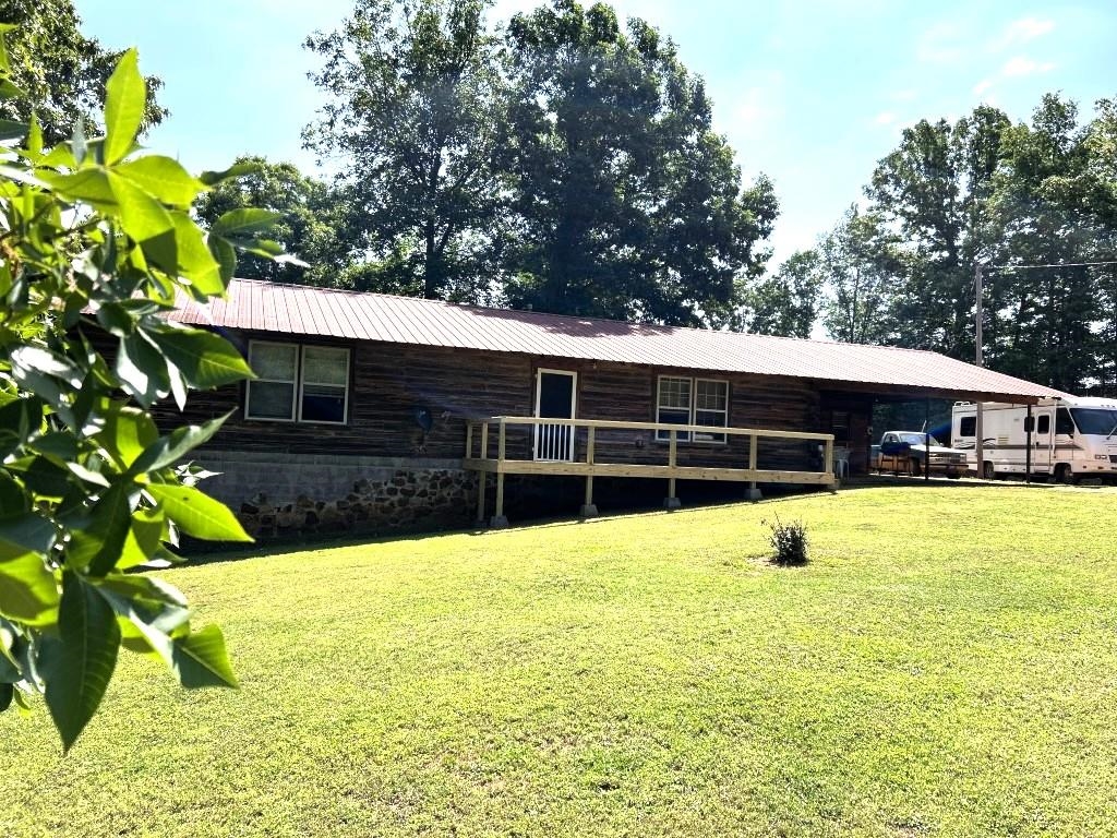 Country Log Home on 10 Acres with Massive Shop!  Enjoy peaceful country living on this beautiful 10-acre property, with abundant wildlife, usable land, and room for your hobbies, livestock, or equipment. This 1512 sq. ft. log home features 2 bedrooms, 1 bath, a spacious great room with propane fireplace, and comfortable country charm throughout. Propane HVAC and propane kitchen range provide added peace of mind during power outages.  Bonus space includes a 196 sq. ft. basement room with both inside and outside access: ideal for storage, office, hobby room, or storm shelter use. Relax on the front and back decks or enjoy the outdoors from the attached carport/sitting area.  Outside improvements include a fenced pasture area, 30x30 implement shed or hay barn, and the standout feature - a 40x50 semi-truck height shop complete with power and half bath. Perfect for mechanics, truck owners, equipment storage, workshop space, or large-scale hobbies.  Hard-to-find combination of country privacy, wildlife, log home appeal, and outstanding shop space!  **$325,000**
