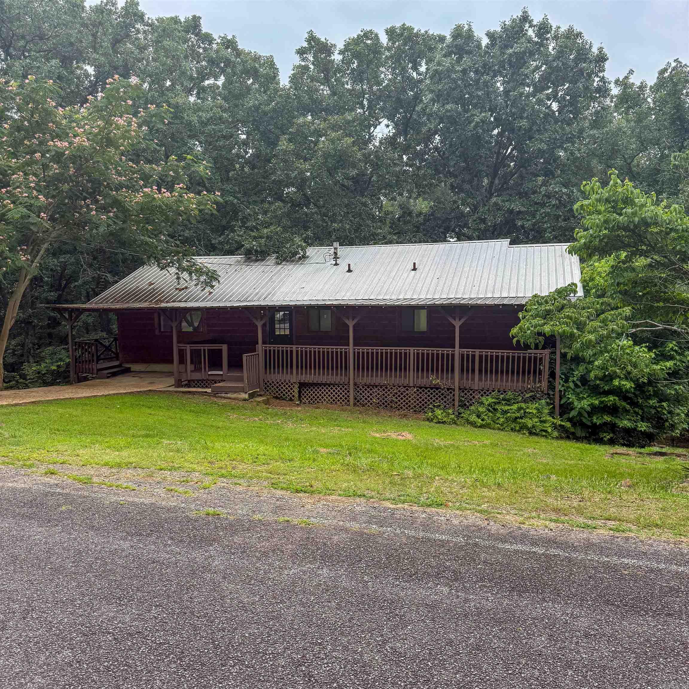 Seller is offering up to $10,000 in buyer concessions with the right offer!  Updated 3BR, 2BA home located just minutes from Greers Ferry Lake and the Lynn Creek public boat launch. Improvements completed in February 2024 include luxury vinyl plank flooring, fresh interior paint, granite countertops, and a glass tile backsplash. Additional updates include select light fixtures and ceiling fans. Metal roof is approximately 5 years old, and the cedar log exterior was installed in 2000.  Enjoy the freshly stained wraparound deck with a covered rear section, perfect for relaxing or entertaining. The home is served by a private septic system, eliminating monthly sewer fees.  Ownership includes access to Fairfield Bay's resort amenities, including golf, hiking and biking trails, ATV/UTV trails, dining, live entertainment, and more. Whether you're looking for a full-time residence, lake-area retreat, or investment property, this home offers great value and convenient access to all that Fairfield Bay and Greers Ferry Lake have to offer.  Property is being sold AS IS. listing shows images virtually rendered to show possibilities.