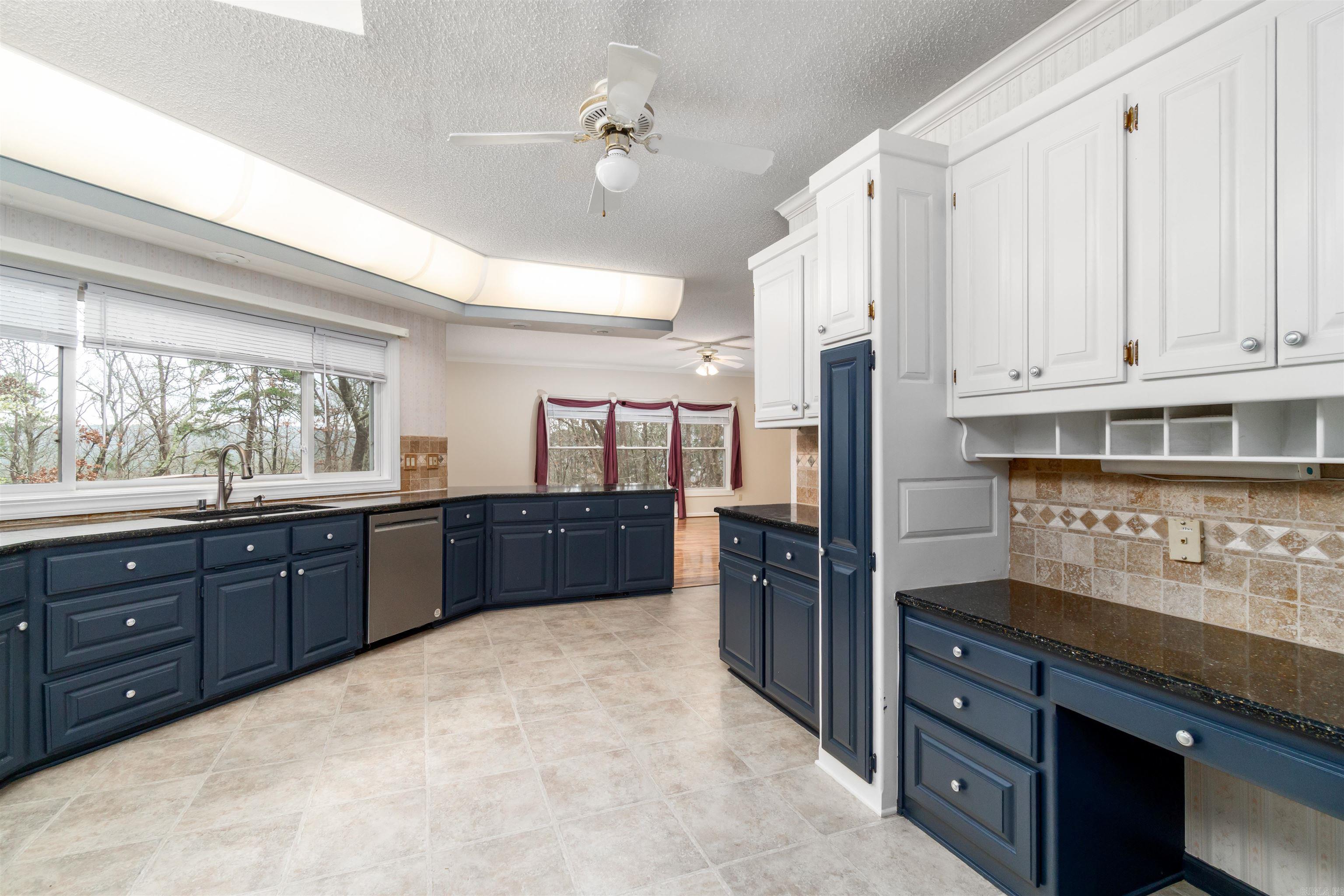 PRICE IMPROVEMENT!! Seasonal views of Lake DeSoto and wooded privacy set the stage for this one-owner 4,000 sq ft retreat at 29 Barcelona Way in Hot Springs Village. Perched among the trees on the desirable West Side, this thoughtfully designed home offers both serenity and versatility.  The main level is ideal for comfortable everyday living with open, light-filled spaces, a spacious primary suite, guest bedroom, full bath, and direct access to scenic outdoor living areas that embrace the surrounding landscape.  The walk-out lower level expands the possibilities with generous living space, full bath, private entrance, and a layout that could easily function as guest quarters, multigenerational living, or a potential lock-out suite.  A dramatic natural rock outcropping has been beautifully integrated into the architecture, creating a striking focal point that celebrates the home’s connection to nature. Now ready for its next chapter, this unique Village property offers buyers the opportunity to bring their vision and make it their own.