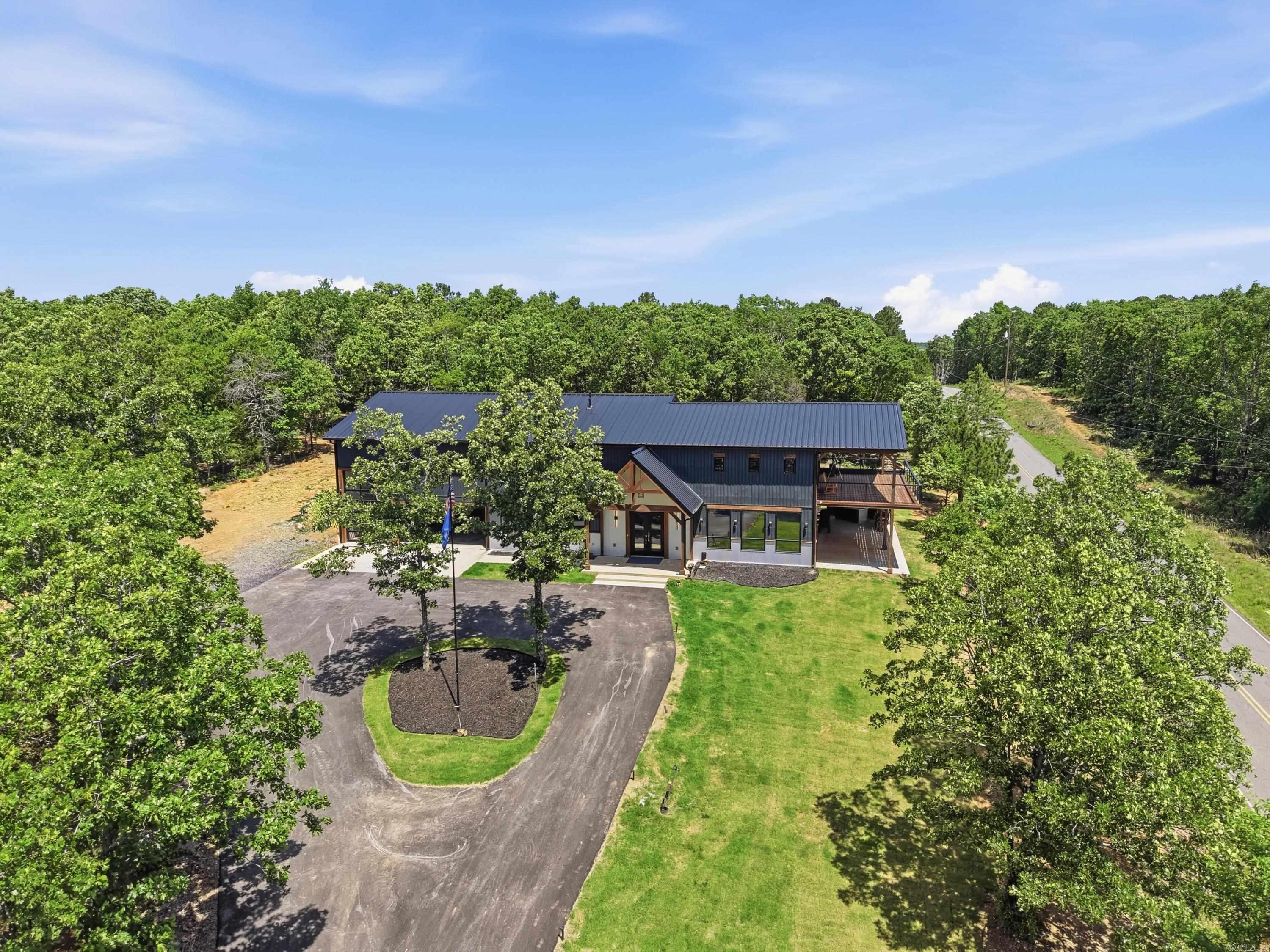 Welcome to 491 Stone Mountain Rd in Conway, Arkansas — a one-of-a-kind modern barndominium offering approximately 3,500 SF of heated and cooled living space plus a 1,200 SF shop area in a prime Central Arkansas location with easy access to Conway, Little Rock, Cabot, and Searcy. This custom home features 3 full baths, 2 half baths, and nearly 1,900 SF of outdoor deck space designed to maximize the incredible views, including nighttime views of the Jacksonville Air Force Base landing strip lights. The luxurious primary suite offers a spa-like wet room with a soaking tub inside the oversized shower plus a programmable steam system for essential oils, creating a true in-home sauna experience. The shop area includes RV hookups and ample space for hobbies, storage, or recreational vehicles. Additional highlights include hot and cold exterior water faucets perfect for washing vehicles or pets and pre-wiring for a whole-home generator. This property seamlessly blends luxury, functionality, and modern design in a truly unique setting.