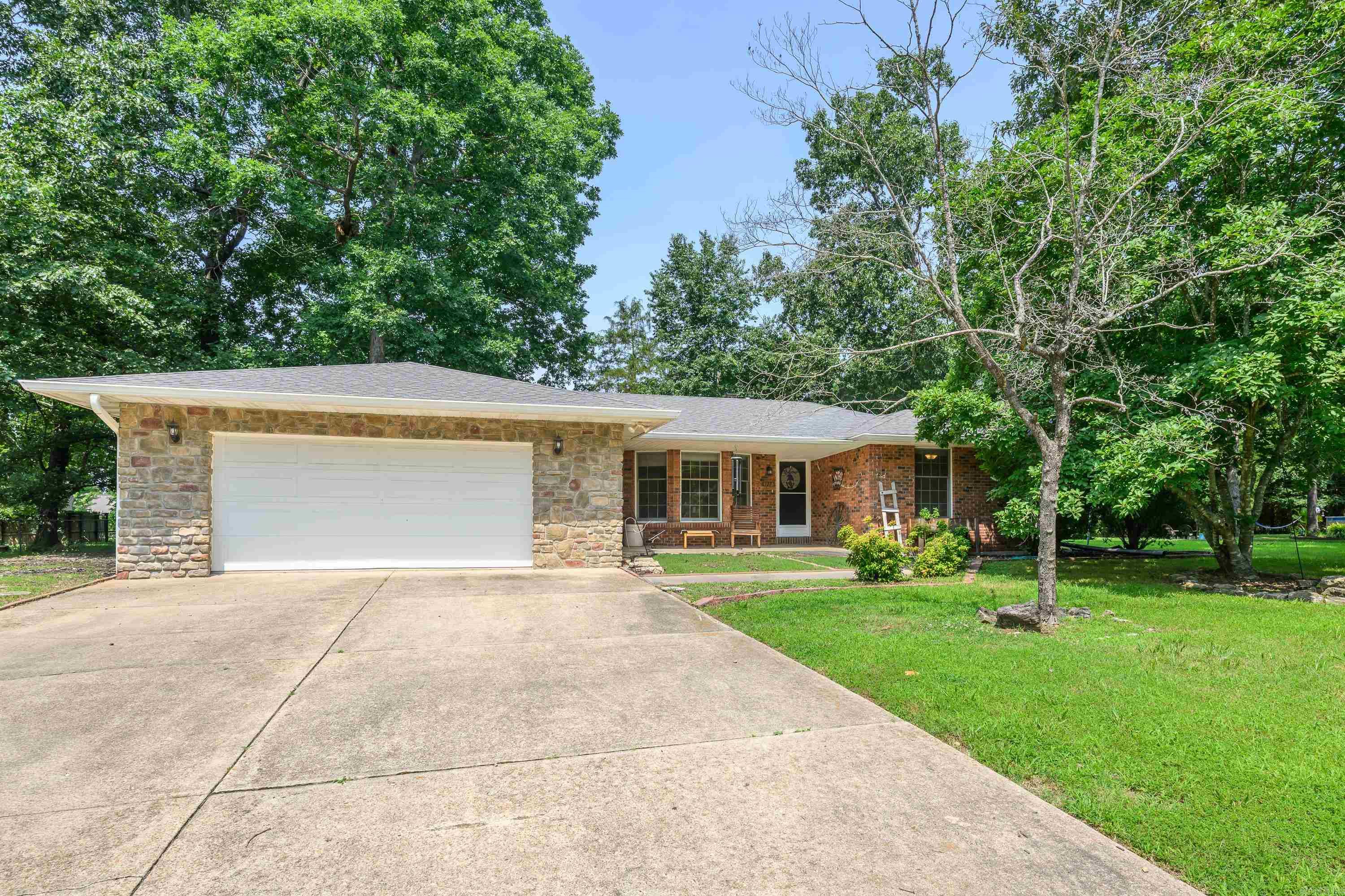 Enjoy easy access to Bull Shoals Lake and the White River from this well-maintained 2-bedroom, 2-bath home in an established neighborhood. The attractive brick and rock exterior is complemented by a newer roof and a two-car attached garage with access to an unfinished basement, perfect for storage. The updated kitchen offers abundant cabinetry, generous countertop space, and all kitchen appliances are included. Relax by the cozy wood-burning fireplace or entertain on the covered back patio overlooking the fenced backyard with a large dog pen and mature shade trees. Situated on two lots, this property provides extra outdoor space while offering comfort, convenience, and a desirable location close to some of the area's best fishing and boating opportunities.