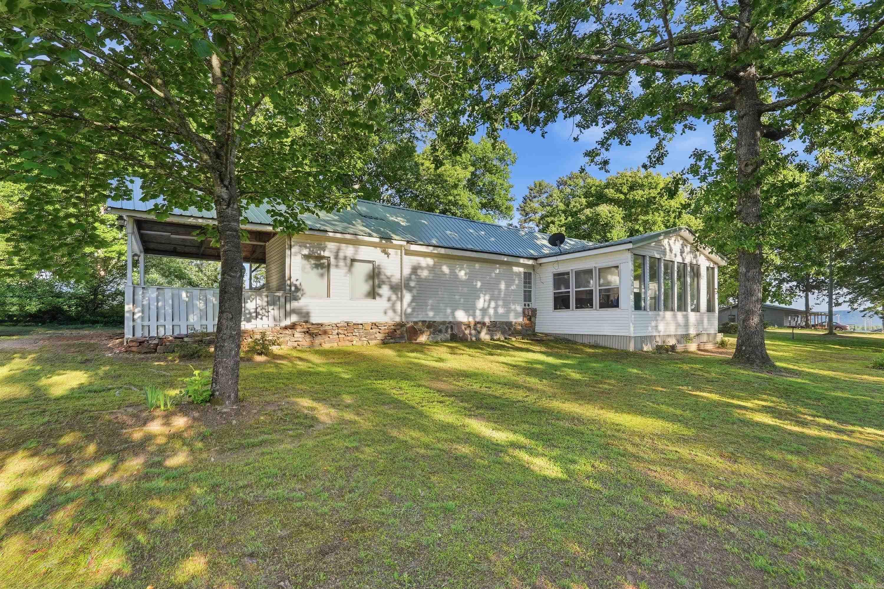 This cozy traditional style two bedroom and two bathroom home is in the heart of Greers Ferry.  Minutes away from the Greers Ferry Lake and both Shiloh and Narrows Marina's.   This home features a breakfast bar, beautiful sun room, the yard has two new fenced off areas with a gates for vehicle access.   This home is walking distance to the Greers Ferry ball park,  with basket ball court, play ground and nice walking trail.   Also,  you can easily walk to the senior center that host serval activities.  This cozy home is located in the inner city of Greers Ferry, land mostly cleared with a some trees.   There is two Heating / Air condition units that convey with the home.