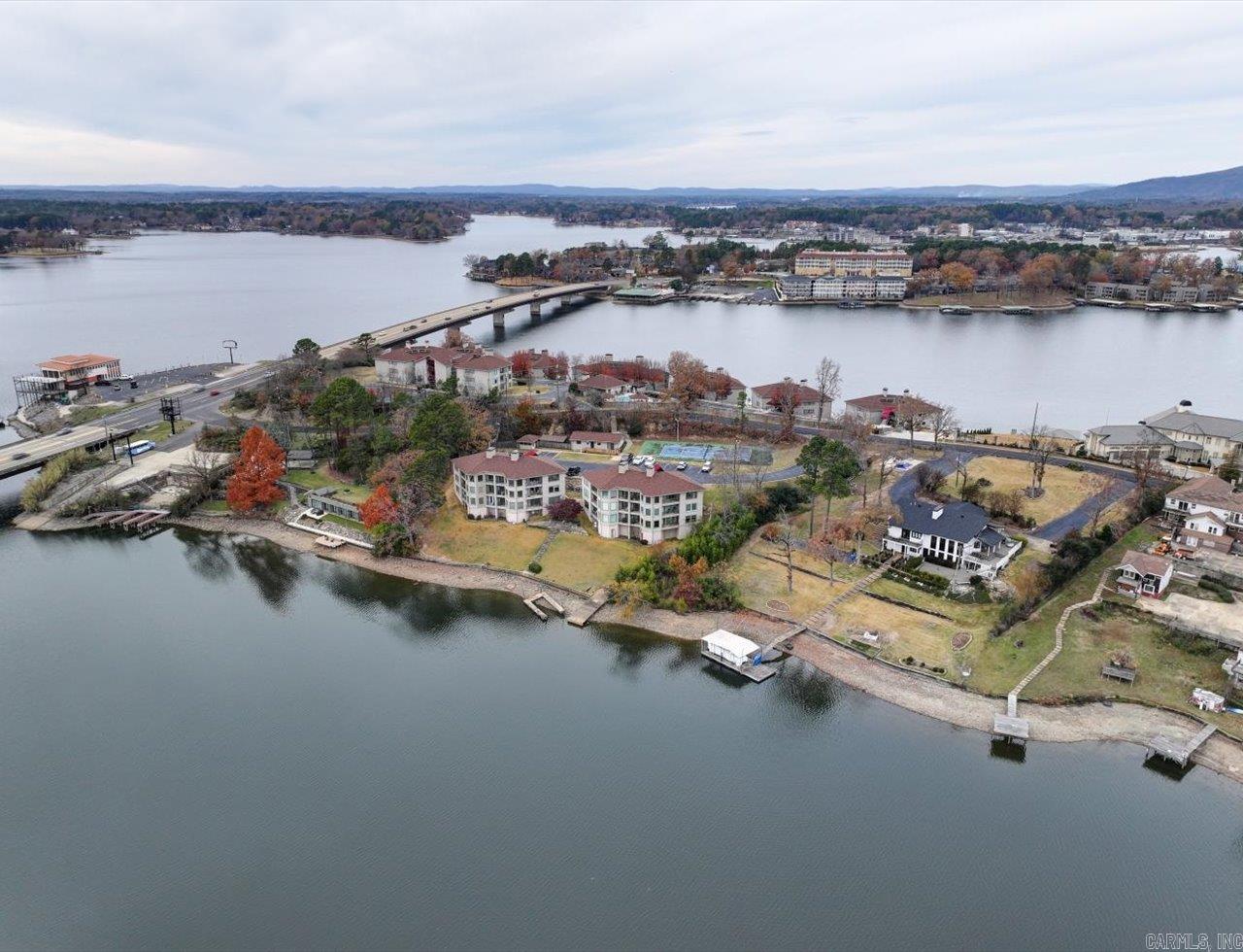 Nightly rentals allowed with covered boat slip and lift, offering excellent income potential or the perfect lake getaway. This completely remodeled, turnkey condo is sold fully furnished and ready for immediate rental or personal enjoyment. The 1,648 SF open, light-filled layout features beautiful lake views. Updates include furniture, flooring, appliances, lighting, plumbing fixtures, solid-core doors, and remodeled bathrooms with soaking tub and upgraded showers. Major improvements include HVAC (2024), roof (2024), and water heater (2022). Relax on the private deck and enjoy easy, protected lake access. Convenient to Hot Springs dining, shopping, and entertainment. Ideal investment, second home, or just get away, relax, and enjoy the lake. Motivated seller—bring offers.