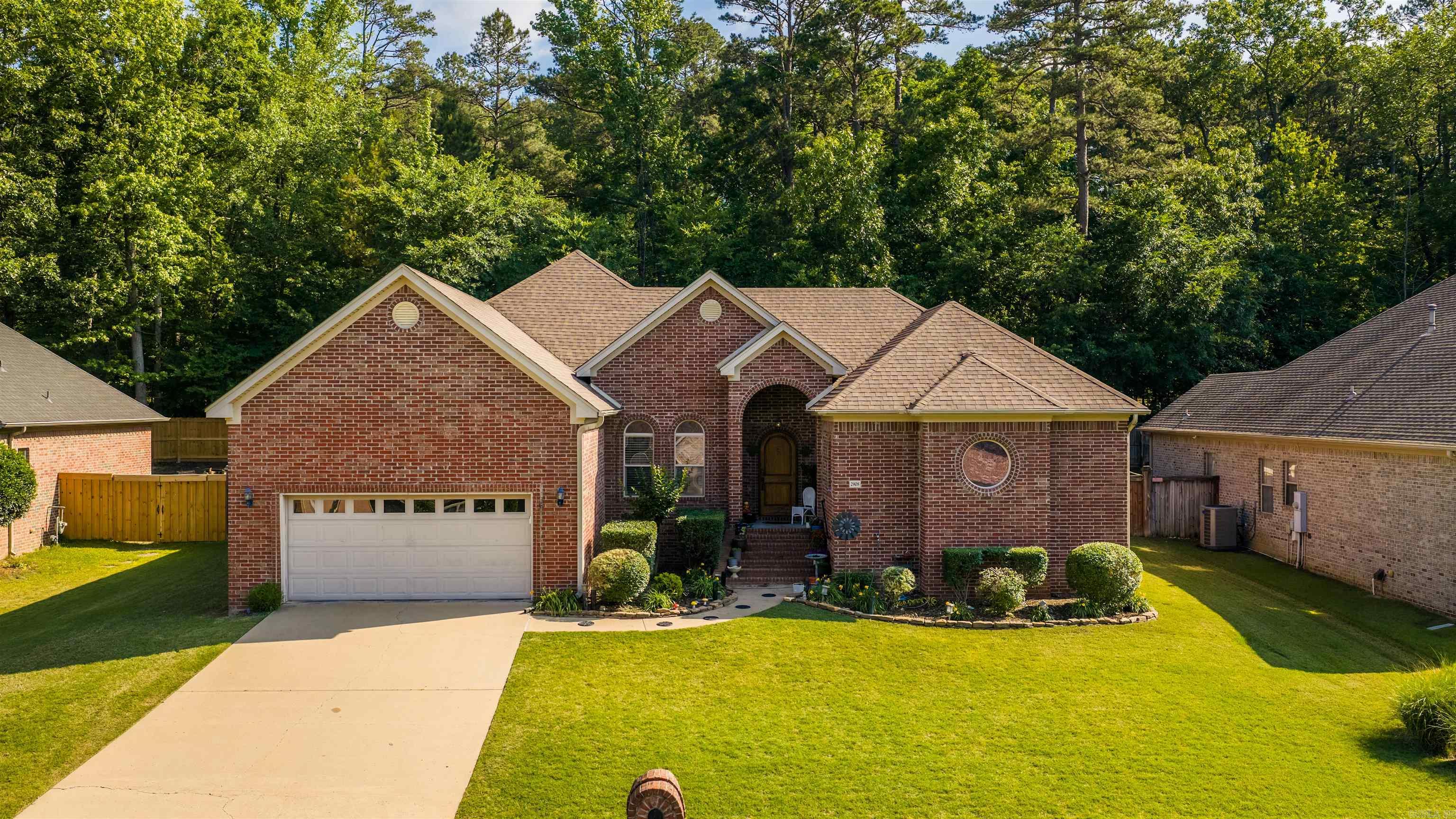 This is a charming all brick beauty with four beds, three baths, and two living rooms in Woodlands Edge of West Little Rock.   With the arched brick entry, you’re welcomed inside to find the nice open plan with the formal dining to the left and large living that flows nicely  into the open kitchen which highlight your granite breakfast bar, a built-in gas stove, walk-in pantry, a breakfast area and spacious hearth room with the stacked stone gas log fire.   Step out to find your big deck overlooking your fully fenced yard with the raised garden beds and playground setup that backs to the protected greenery.  Privately set apart is the sizable primary suite with the private vanities, Jetted tub, walk-in seated shower, and dual walk-in closets.   Don’t miss the workstation / office nook adjacent to the kitchen by the guest bed & bath with the knee space vanity and walk-in shower.