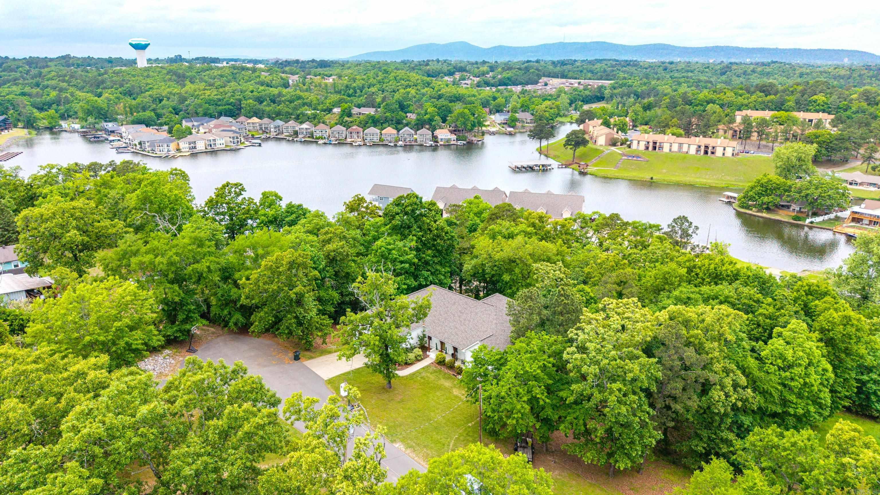 Welcome to this stunning custom-built home, completed in 2019, offering breathtaking panoramic views of West Mountain and Lake Hamilton. Nestled on a private 1-acre lot at the end of a quiet cul-de-sac, this property delivers the perfect blend of luxury, space, and serenity.  With 3,100 square feet of thoughtfully designed living space, this home features 5 spacious bedrooms and 3.5 bathrooms, providing flexibility for families, guests, or a home office setup. Beautiful hardwood floors flow throughout, adding warmth and elegance to every room.  The master suite is truly an oasis, designed for comfort and relaxation with ample space and privacy. The home’s flexible layout allows you to tailor the space to your lifestyle needs, whether for entertaining, working from home, or multi-generational living.  Step outside and take in the views from the expansive upper and lower decks—perfect for morning coffee, evening sunsets, or hosting gatherings.  Located in the highly desirable Lakeside School District, this property combines convenience with peaceful, private living.  Don’t miss the opportunity to own a modern, custom home with unmatched views and exceptional features.