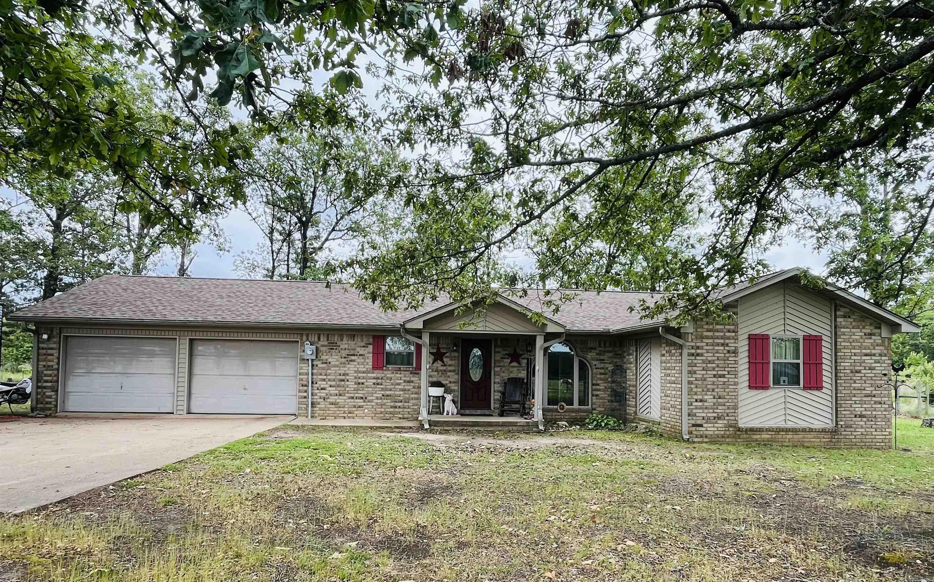 Enjoy peaceful country living with this beautiful property featuring approximately 20.73 fenced acres, 2 ponds, and plenty of space for animals, gardening, and outdoor living. The home offers a cozy woodburning fireplace with thermostat and insert, granite countertops, mosaic tile backsplash, and a new stainless steel dishwasher in the kitchen. Bathrooms feature granite top vanities, ceramic mosaic tile, a walk-in tiled shower in one bath, and a tub/shower combo in the other. Additional features include Brazilian hardwood flooring in the kitchen, dining room, living room, and one bedroom, tile flooring in the bathrooms and laundry room, double hung insulated windows, PEX plumbing, and an approximate 5-year-old architectural shingle roof with ridge cap. Outside you’ll find a concrete patio, basketball goal, treehouse, and plenty of room to enjoy the outdoors. Property improvements include a 30x40 barn with 4 stalls and tack room, 16x12 shed with two lofts, 20x20 storage building with lean-to tractor shed, and an 18x18 dog pen with concrete floor. A great opportunity to enjoy quiet country living with room to spread out! This one is a must see! Message me for the video!