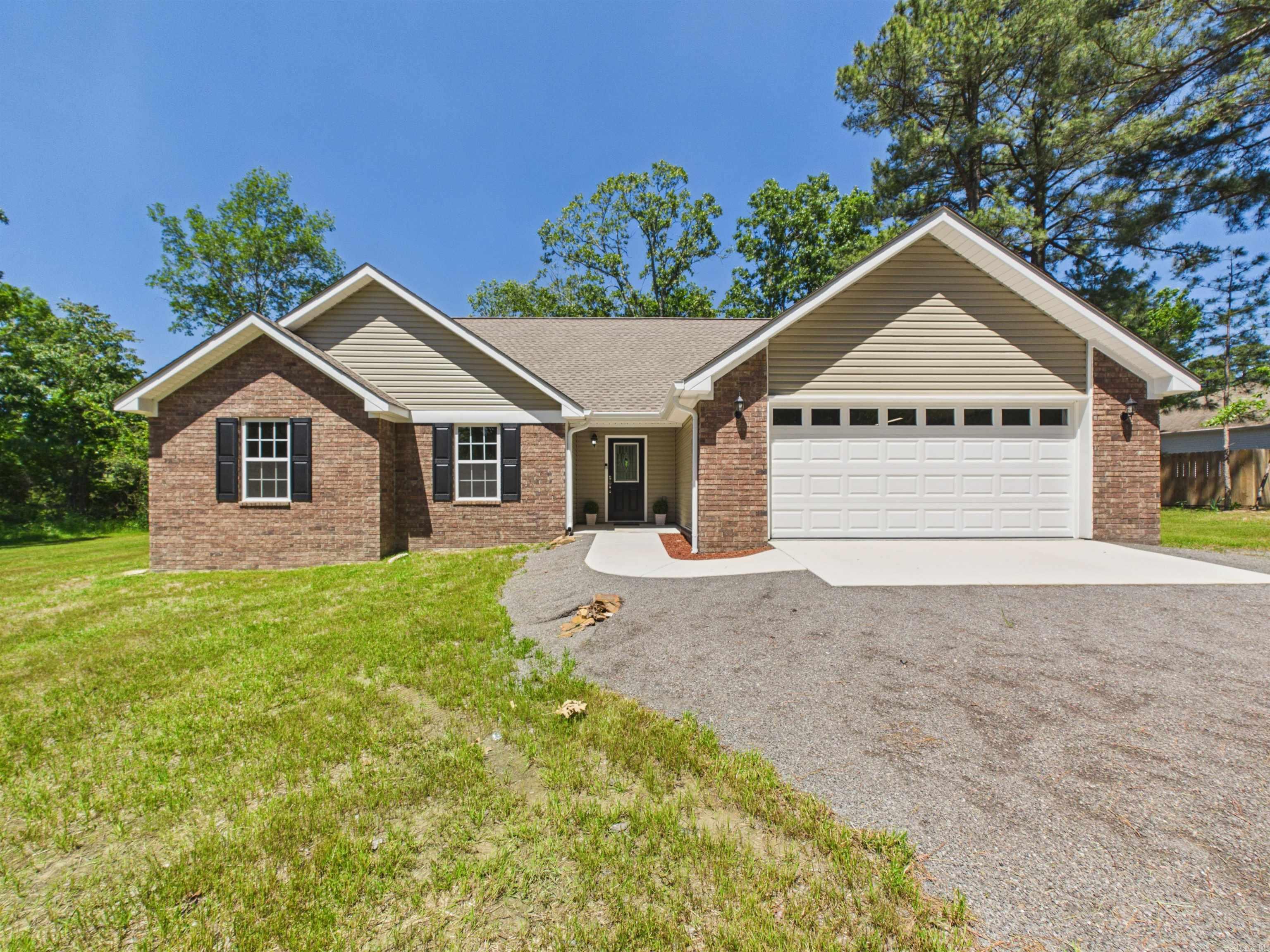 Welcome to this brand-new custom-built home at 100 Shackelford Drive, offering 3 bedrooms, 2 bathrooms, and a thoughtfully designed layout just minutes from Southside School and Batesville, AR. If you’ve been searching for a new construction home near Batesville with modern finishes and natural surroundings, this one is a must-see. Step inside to soaring vaulted ceilings, a stunning back wall of windows, and an open-concept living area filled with natural light. The spacious living room features a cozy gas fireplace, creating the perfect gathering space. The kitchen offers crisp white cabinetry, a pantry lined with shelving, a large island with seating, single-basin sink, and black and stainless appliances including an electric cookstove, microwave vent-a-hood, and dishwasher. French doors lead to a covered back patio overlooking the peaceful backyard. The split floor plan provides privacy, with a beautiful primary suite featuring tray ceilings, double vanities, a custom soaking tub with bench seating, walk-in shower, and abundant natural light. Two additional bedrooms and a full bath are located on the opposite side of the home. This is in Southside!