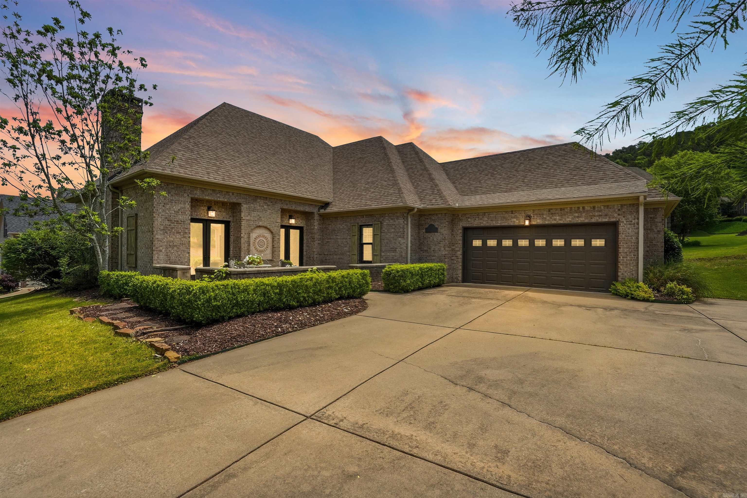 Welcome to 143 Courts Lane, a charming home in the Courts neighborhood of Chenal Valley, positioned on a spacious corner lot with a welcoming courtyard, additional parking, and mature landscaping. The stunning interiors blend soft Country French influence with a romantic Restoration Hardware-inspired feel, offering warm finishes, elegant details, and beautifully scaled spaces. The great room with a gas-log fireplace, built-ins, and soaring 12-foot ceilings is open to the formal dining room. A covered side porch is perfect for morning coffee. The kitchen features double islands, granite countertops, new gas cooktop with vent-a-hood, double ovens, refrigerator, KitchenAid ice maker, dishwasher, microwave, walk-in pantry, and breakfast area. The main-level primary suite offers hardwood floors, his-and-her closets, double sinks, Jacuzzi tub, walk-in shower, and private water closet. Two guest suites with private en-suite bathrooms are also on the main level. Upstairs includes a media room, half bath, two bedrooms and a full bathroom. Backyard features sprinkler system, grassed area, and deck. Extras include Ecobee Wi-Fi thermostats, two-car garage, new carpet plus more!