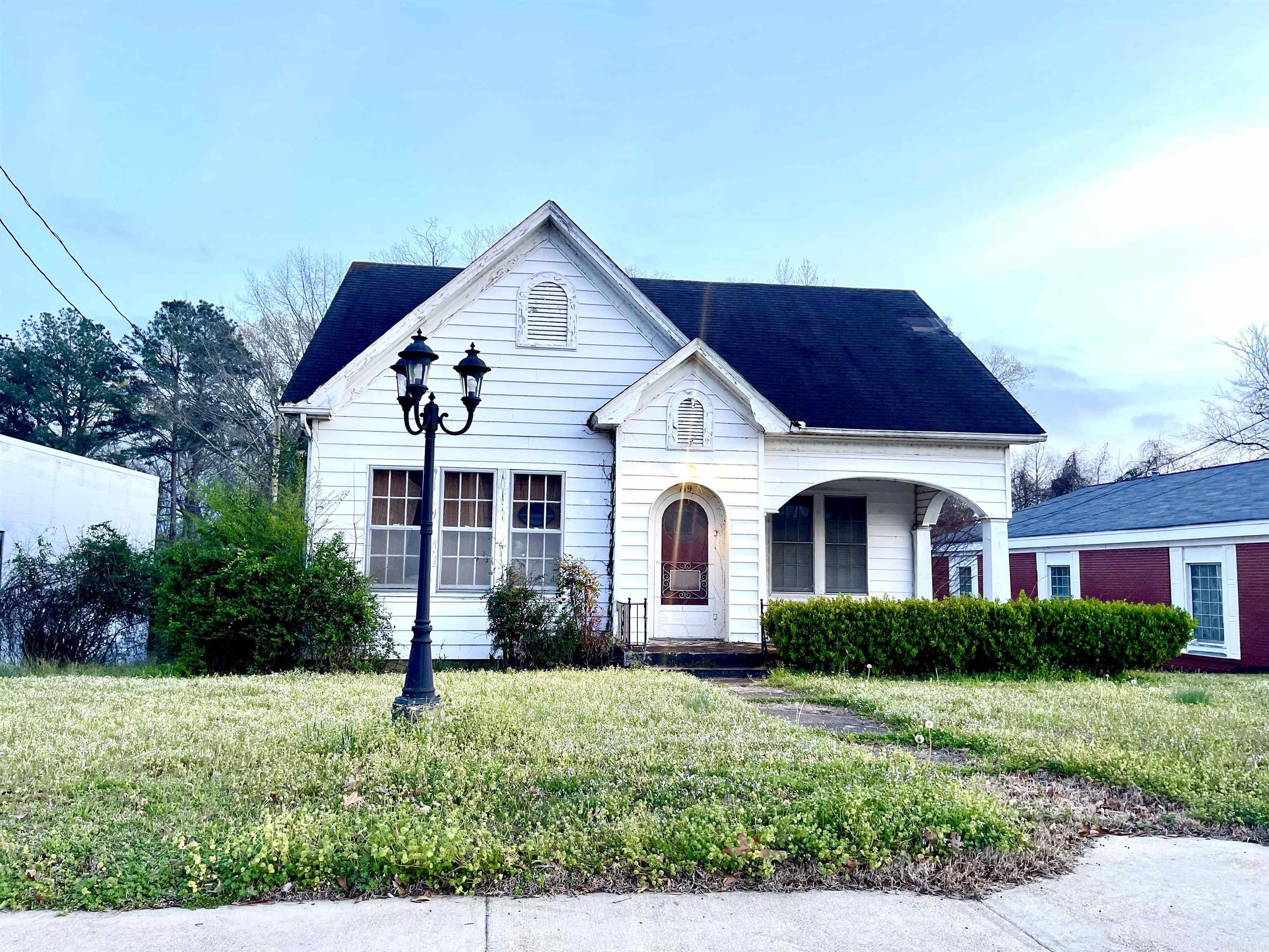 Character abounds in this 1930's build!  Located in the heart of downtown across from the courthouse, it can serve as an office under C1 zoning, or as a residence under its present configuration.  The interior features arched woodwork, bay windows, original hardwood floors, and raised ceilings.  It truly captures the personality of a historic home, while it's received some modern amenities through the years.  Don't miss out on this rare find!  Priority will be given to offers that accept the home as-is with the right to inspections. *$9,800 roof credit at closing with acceptable offer*