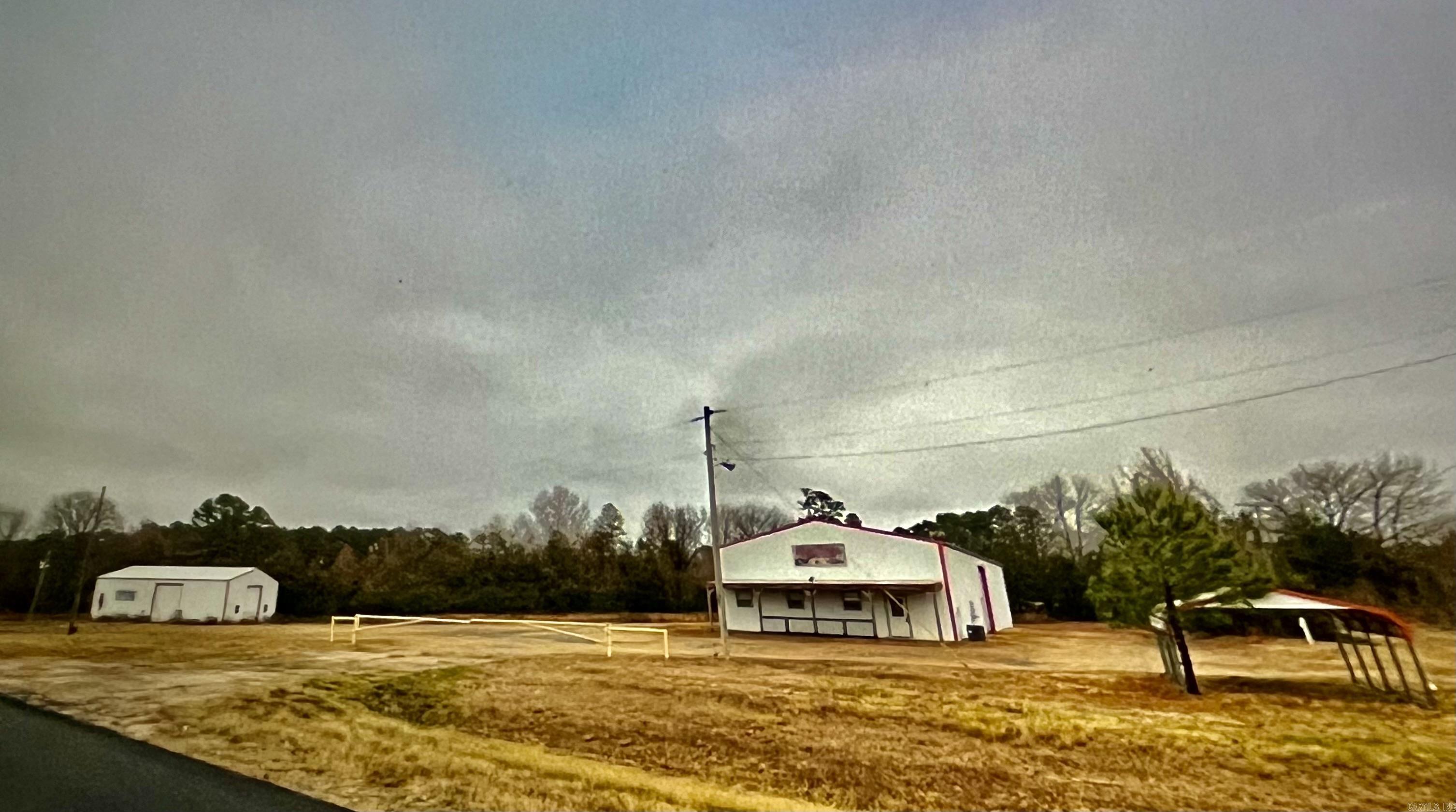 This property boasts a potential income stream and versatile usage options, including many RV hookups, shops, or a residential barn ammonium, with the added benefits of two separate entrances via iron gates on Highway 65 frontages. Situated just outside the city limits with no zoning restrictions, this property offers a unique opportunity for diverse uses, including commercial and residential. With its strategic location on Highway 65 and absence of zoning regulations, this property presents an attractive option for those seeking flexibility in its use, whether for income generation to personal pursuits. Featuring multiple potential uses and situated on a prominent highway with gated entrances, this property could be an excellent or a dream location for private residence or business.