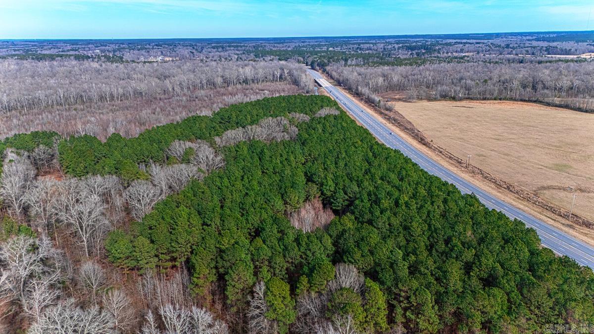 This property offers (approx.) 72 total acres, including a dedicated one-acre building site and access to 71 additional acres ideal for hunting. The land features a diverse landscape of bottomland, hardwoods, a small pond at the southern end, and a natural creek. Please note that while the bottomland is situated within a flood zone, the designated building site appears to be clear of this area; however, this should be verified with a lender. The property is unrestricted, making it suitable for livestock and various animals. Access from Highway 167 will require an approved driveway permit.