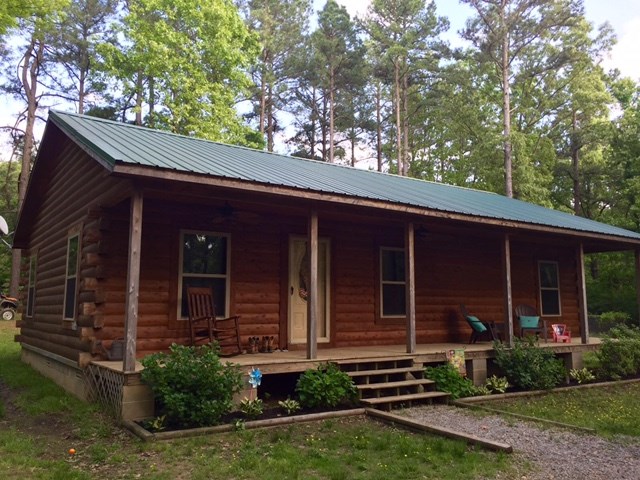 Gorgeous log home surrounded by an acre of woods. You can enjoy sitting in your rockingchair on the full length covered front proch.  Stepping into this home you are welcomed by a rustic gas fireplace accented with stone from floor to ceiling.  This is a place you can feel at home in!