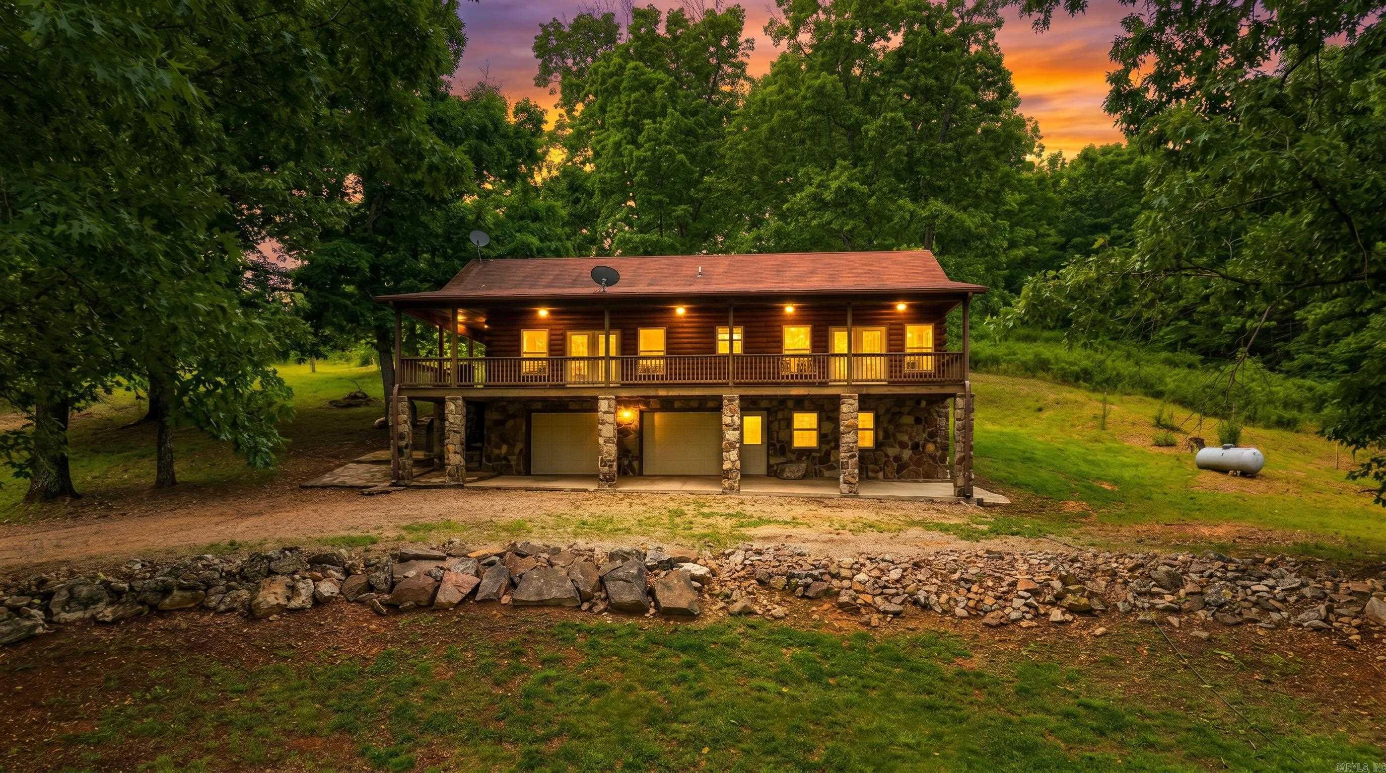 Escape to the peace and privacy of the Missouri Ozarks with this beautiful country home and hobby farm situated on 5 surveyed acres just off a paved highway. Tucked back from the road with no visible neighbors, this property offers the perfect blend of privacy, convenience, and usable acreage. The spacious home features approximately 2,700 square feet of living space with a warm rustic feel, vaulted ceilings, and an open living room and kitchen floor plan ideal for comfortable country living and entertaining.  A large covered wraparound porch provides the perfect setting to relax and enjoy sunsets, wildlife, and the peaceful Ozarks atmosphere. Inside, the home offers 2 oversized upstairs bedrooms, 2 full bathrooms, and a full walkout basement with additional living space, storage, a large bathroom with an oversized jacuzzi tub, and potential for a third non-conforming bedroom.  Outside, the hobby farm setup includes a stocked pond filled with catfish, bass, bluegill, and carp along with numerous fruit-producing plants and trees. Additional features include a private well, attached 2-car garage, walkout basement access, and a roof only 6 years old. This Southern Missouri property is