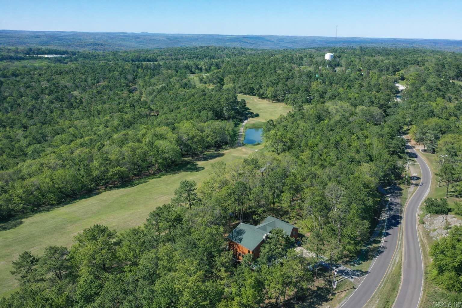 5BR Golf Course Home in Fairfield Bay – Overlooking Indian Hills #7 & #8 with Waterfall Views! Situated on two lots backing up to hole #7, this spacious 5-bedroom, 4.5-bath home offers 3,615 sq ft of well-designed living space on the scenic Indian Hills Golf Course in Fairfield Bay. The main level features an open dining and living area anchored by a stone fireplace. Step out onto the front deck, where you can overlook the tee box of hole #8 and enjoy the relaxing sound of a nearby waterfall—a truly unique setting. A separate den with patio doors leads to another deck overlooking hole #7. The Master suite is also on the main level with multiple vantage points to take in the beauty of the course. Upstairs, you’ll find 4 bedrooms and 3 full baths, two being en suite bedrooms, each with private deck access overlooking the golf course. One bedroom features an adjoining playroom or flex space, perfect for kids, guests, or a hobby area. Additional features include a 24x36 garage, a safe room located beneath the side deck, and low-maintenance construction with cement Hardie board siding and composite decking—designed for durability and easy upkeep. Enjoy access to Fairfield Bay amenities