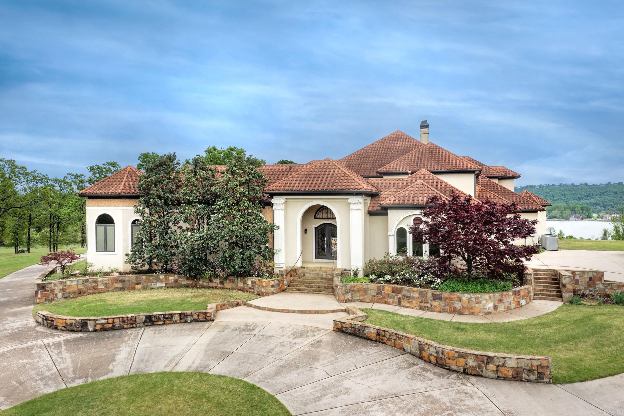 Splendid estate situated on 2.38 acres in a small gated community with views of the AR river from every window in the back of the home. Stunning features include grand 2 story entry with a curved staircase, Swarovski crystal chandeliers, coffered ceilings, custom hand painting throughout, rich wood and trim work. Courtyard saltwater pool with FP and separate home theater with bar. Main level -dining and living room; library w/ Mahogany walls; gourmet kitchen equipped with Thermador commercial grade 6 burner stove with pot filler, GE monogram refrigerator & freezer & more high end amenities, double island plus a wet bar that opens to an eat-in area & hearth room with a FP; Primary suite with 2 sitting areas & beautifully appointed bathroom with large walk in shower, jacuzzi; & a separate private guest suite with full bath. Upstairs-Large game room with full BA, separate bedroom suite w/ private bath w/ jacuzzi tub & 2 bedrooms that share a walk through bathroom. Total of 4 car side load garage.Stucco exterior w/ tile metal roof. Sprinkler system. Alarm system. Low E Pella windows. Leaf Guard guttering. Enjoy the view of the river on the spacious covered veranda w/ an outdoor kitchen