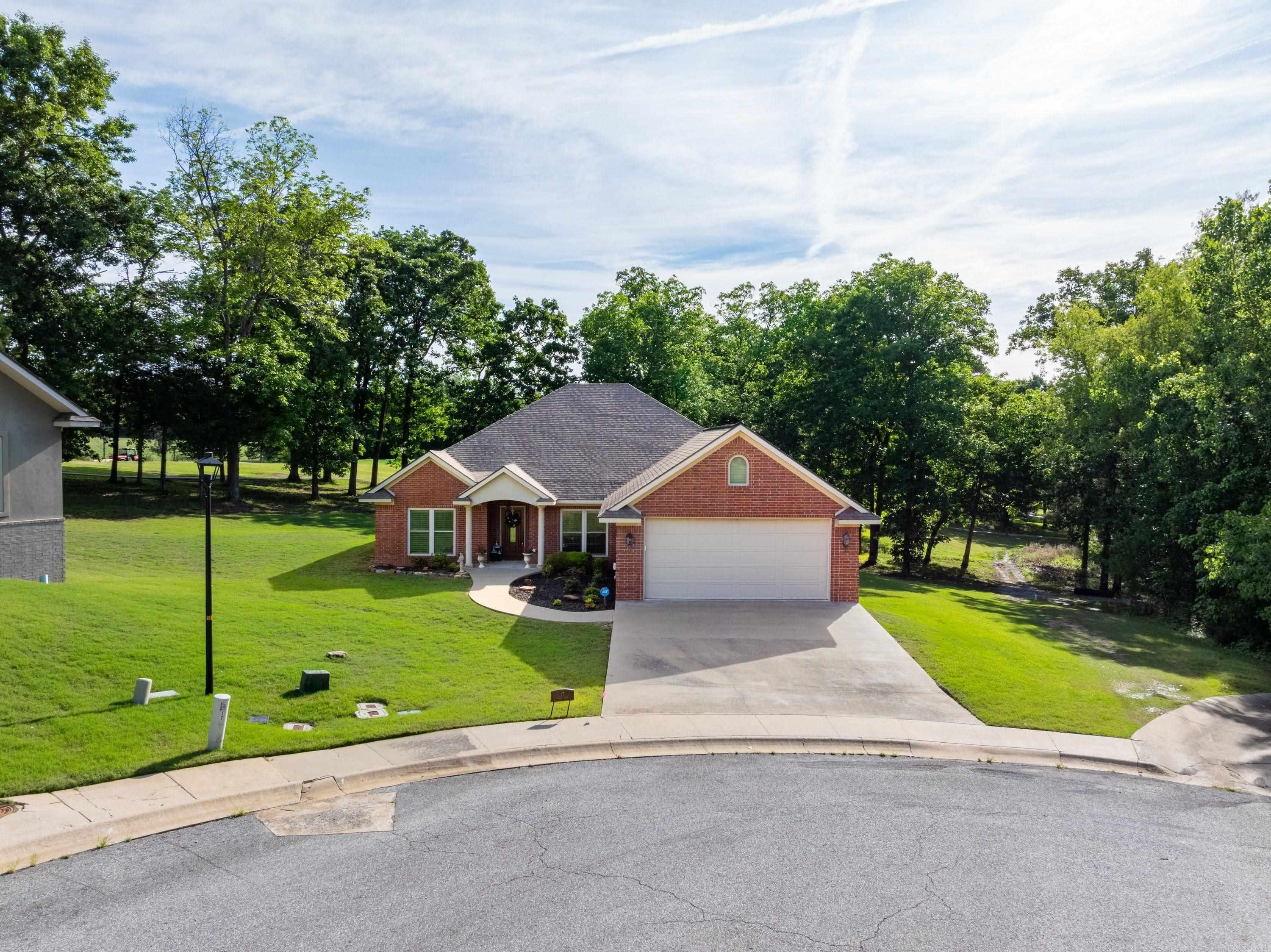 Beautiful 3 bed, 2 bath brick home on the golf course in The Village at Eagle Mountain, located on a quiet cul-de-sac on Valley View Road in Batesville, AR. Overlooking Hole #3, this home offers great views and a peaceful setting just minutes from White River Medical Center, shopping, and dining. Inside, you’ll find a bright, open layout with a vaulted ceiling in the living room, gas log fireplace, and plenty of natural light. A dining area sits just off the entry, while the galley kitchen with breakfast area overlooks the golf course and leads to a covered back porch and patio, perfect for relaxing or entertaining. The split floor plan includes two guest bedrooms and a full bath with double sinks on one side, and a private primary suite on the other featuring a custom bathroom with double sinks, vanity area, walk-in shower, private toilet room, and large walk-in closet. Additional features include laundry room with sink and storage, custom wood blinds, natural gas, sprinkler system, sump pump, attic storage with stair access, and a 2-car garage. Built in 2012, this well-maintained home offers comfort, quality, and a great golf course location.
