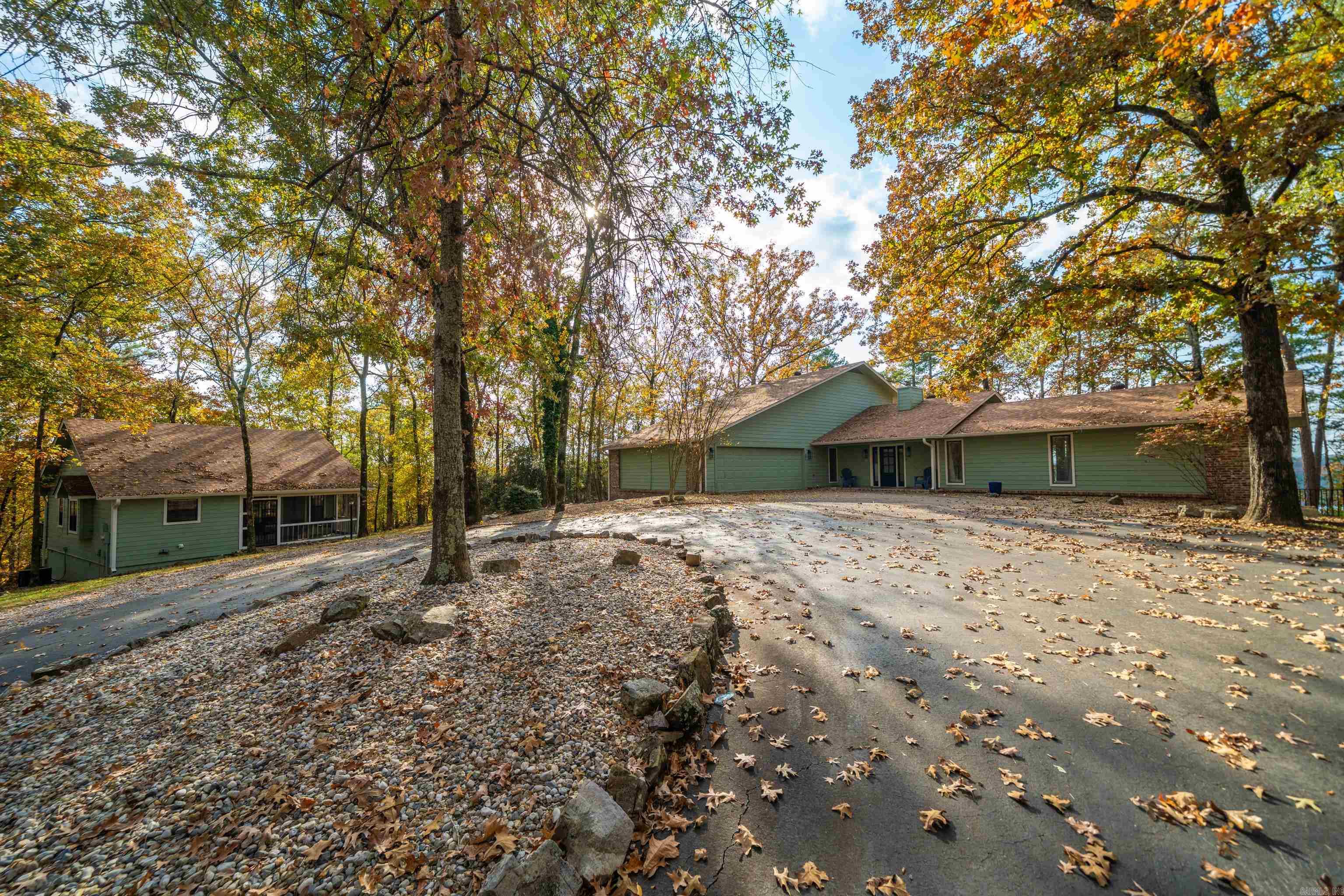 Presenting a rare opportunity to own two exceptional homes, sold fully turn-key, on 2.78 acres of beautifully manicured, unrestricted lakefront property. This remarkable estate blends privacy, luxury, and unmatched versatility, set along 100 feet of pristine shoreline with serene views and direct water access. The main residence offers 2,423 sq. ft. of refined living space, featuring 3 spacious bedrooms,3.5 baths, and a dedicated office currently being used as a fourth bedroom. Thoughtfully designed for comfort and entertaining, it provides an inviting atmosphere for memorable lakefront living and comfortably hosts gatherings of family and friends. The charming guest house adds another 880 sq. ft. with 1 bedroom, 1 bath, and a bright, airy sunroom that offers additional sleeping space. Perfect for extended family, guests, or multi-generational living, it delivers exceptional flexibility. With no property restrictions, there is even potential to add an additional small home to further enhance the estate. Outdoors, the property truly shines with an inground pool, hot tub, firepit, and a floating covered boat slip—everything desired for an effortless lake lifestyle.