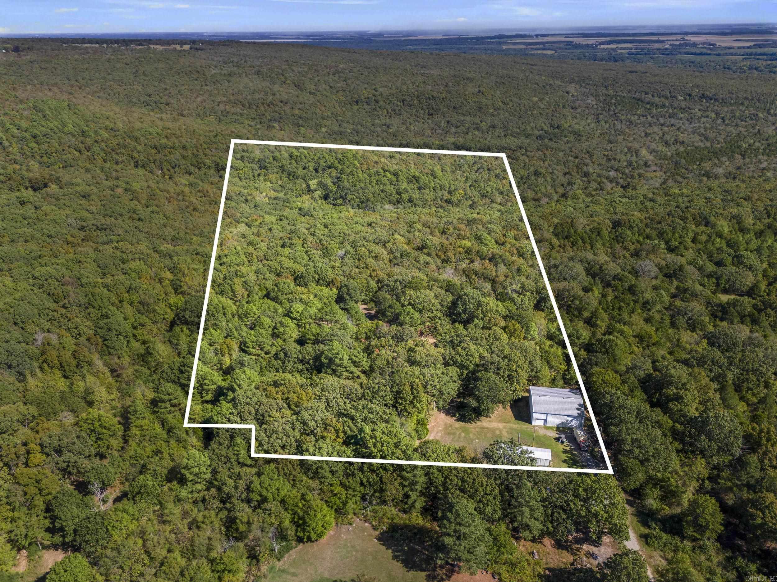Looking for peaceful country living with space to spread out? This property offers nearly 20 acres outside the city limits with no restrictions, giving you the freedom to build your dream home or place a new mobile home. Utilities are already in place — water, septic, and electric are installed and ready to go. The property has its own driveway and another driveway on the other side for convenience. Also, much of the land is wooded, making it an ideal spot for hunting or creating your private retreat. A 50x45 shop with two large garage doors, electricity, front and back doors is included and features a half bathroom that’s already connected to the septic system — 1/2-bathroom does need finished out. Enjoy peace, privacy, and endless possibilities with this one-of-a-kind property! There is another flat spot on the land down from the shop that could be a great spot for a home, but someone would need to work on utilities for that spot. Seasonal creek runs on the property! Beautiful trees! The current mobile home can be removed before closing, and all items in the shop and equipment on the land will be removed from the property prior to closing. Property lines are approx. in photos!!!