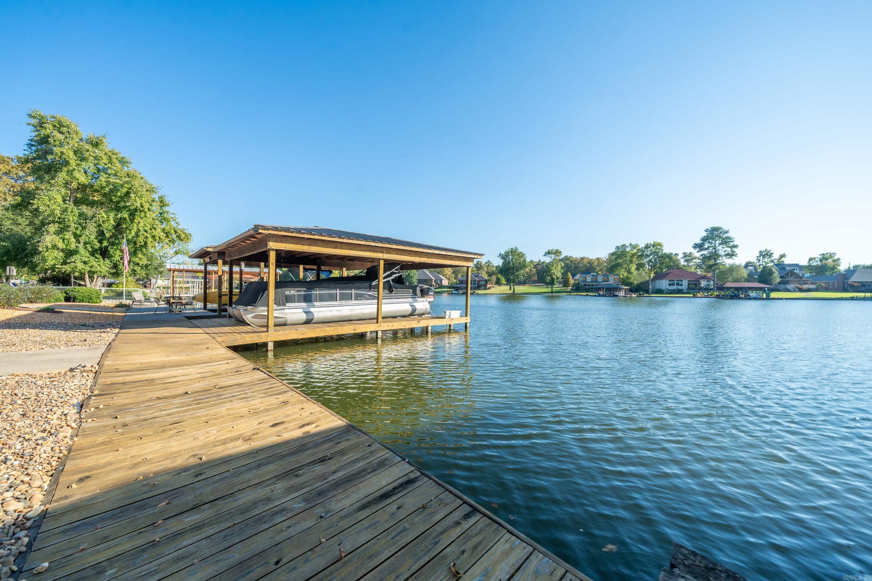 Welcome to your dream getaway on the serene shores of Lake Hamilton! This stunning 3-bedroom, 3-bathroom home offers the perfect blend of comfort and luxury. Enjoy your private boat dock with a lift, making water adventures easily accessible. Inside, you’ll find a spacious and inviting layout, featuring a bright living area that flows into a well-equipped kitchen, perfect for entertaining family and friends. The expansive back porch, complete with a cozy fireplace, invites you to unwind and soak in the breathtaking lake views—ideal for morning coffee or evening gatherings. With ample outdoor space and easy access to the water, this property is a true haven for water lovers and those seeking relaxation. Don’t miss your chance to own this beautiful slice of paradise on Lake Hamilton!
