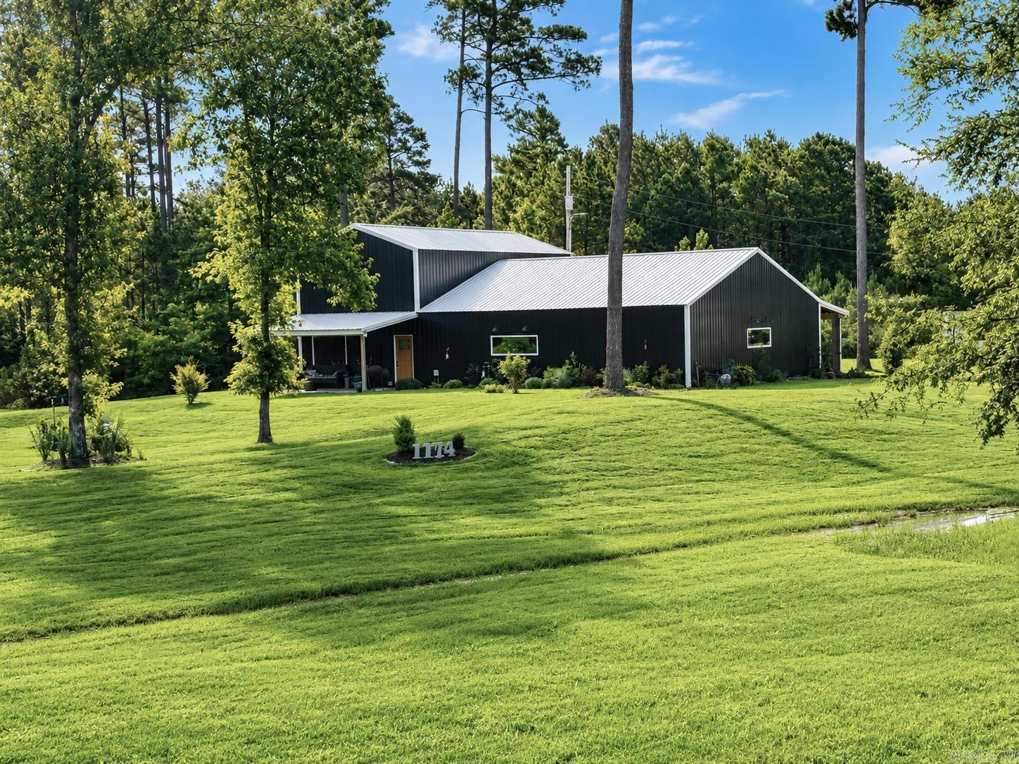 Wide-open views and one-of-a-kind living await in this spacious barndominium on 5.63 acres! With 2,960 square feet, 2 bedrooms, 2.5 baths, and two kitchens, this property is designed for comfortable living and entertaining, with room to accommodate 50+ guests.  The upstairs master suite features 800 square feet, a walk-in closet, and a nice walk-in shower. while the main living areas showcase beautiful double v groove pine shiplap walls and sharp black metal siding for a modern country look. The main kitchen is full of personal touches; the pictures speak for themselves. The enjoy high-speed fiber internet, a walk-in pantry, low average electric bills of about $200/month, and propane already stubbed into the living room if needed.  Outdoor features include a 60x12 back porch, 20x12 front porch, greenhouse, garden area, extra landscaping, full camper hookups with its own septic and a separate home site with septic, driveway and water lines! A new survey is available. Unique and a cool place!