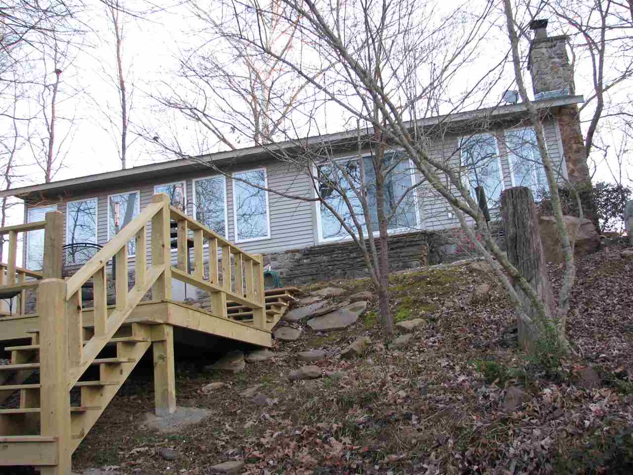 This is a beautiful, well maintained home on two riverfront lots with Boat dock and wood walkway. Subdivision features a grass airstrip.Grounds have been kept to maximize shaded privacy,and cool summer enjoyment. The open floor plan and expansive windows allow you to view the river and nature while enjoying friends and family. Plenty of room for family and friends. A large garage for parking and boat storage. It has a poured concrete safe room in the house. Furnishings are negotiable.