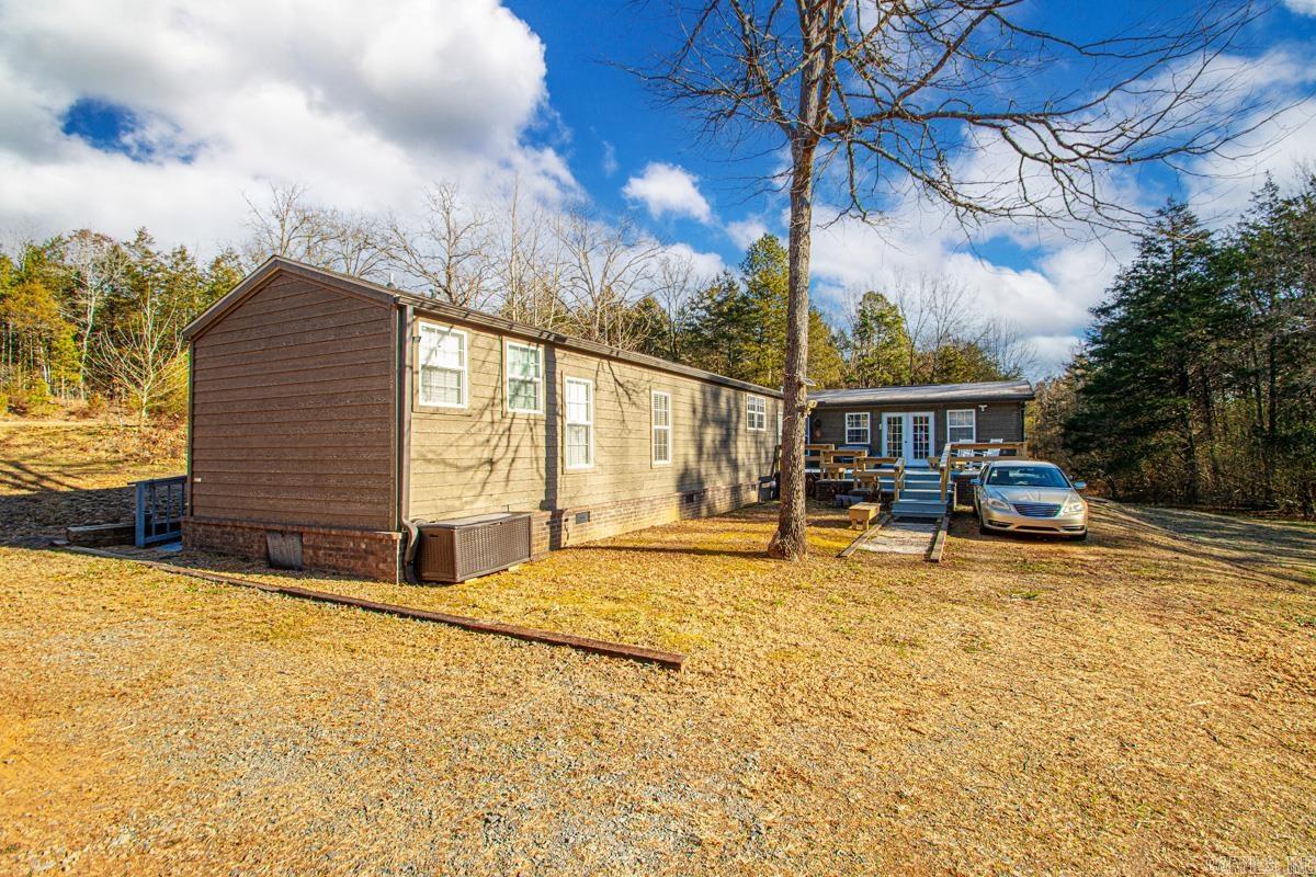 If you’ve been searching for acreage with water, privacy, and real flexibility, this one stands apart. Set on 6 beautiful, usable acres with a year-round creek, this 2015-built home offers a rare blend of modern comfort and true Arkansas outdoor living. The creek is wide, flowing, and deep enough to swim or float, creating a peaceful backdrop you’ll enjoy every single day.  The 1,759 sq ft home features 2 bedrooms and 1.5 baths, plus a dedicated office that could easily function as a third bedroom if enclosed. The spacious primary suite includes a large walk-in closet, and the kitchen is thoughtfully designed with a tall breakfast bar and built-in refrigerator that conveys.  A 24x24 addition adds serious potential, offering space for future bedrooms, a second bathroom, or expanded living area. Outside, a new 16x16 front deck overlooks the property and creek, while a rear wheelchair-accessible ramp adds functionality and ease of access.  Wildlife is abundant, privacy is exceptional, and the setting feels worlds away—yet you’re still just minutes from town. Properties with land, water, and this level of versatility are increasingly hard to find. This one delivers all three.