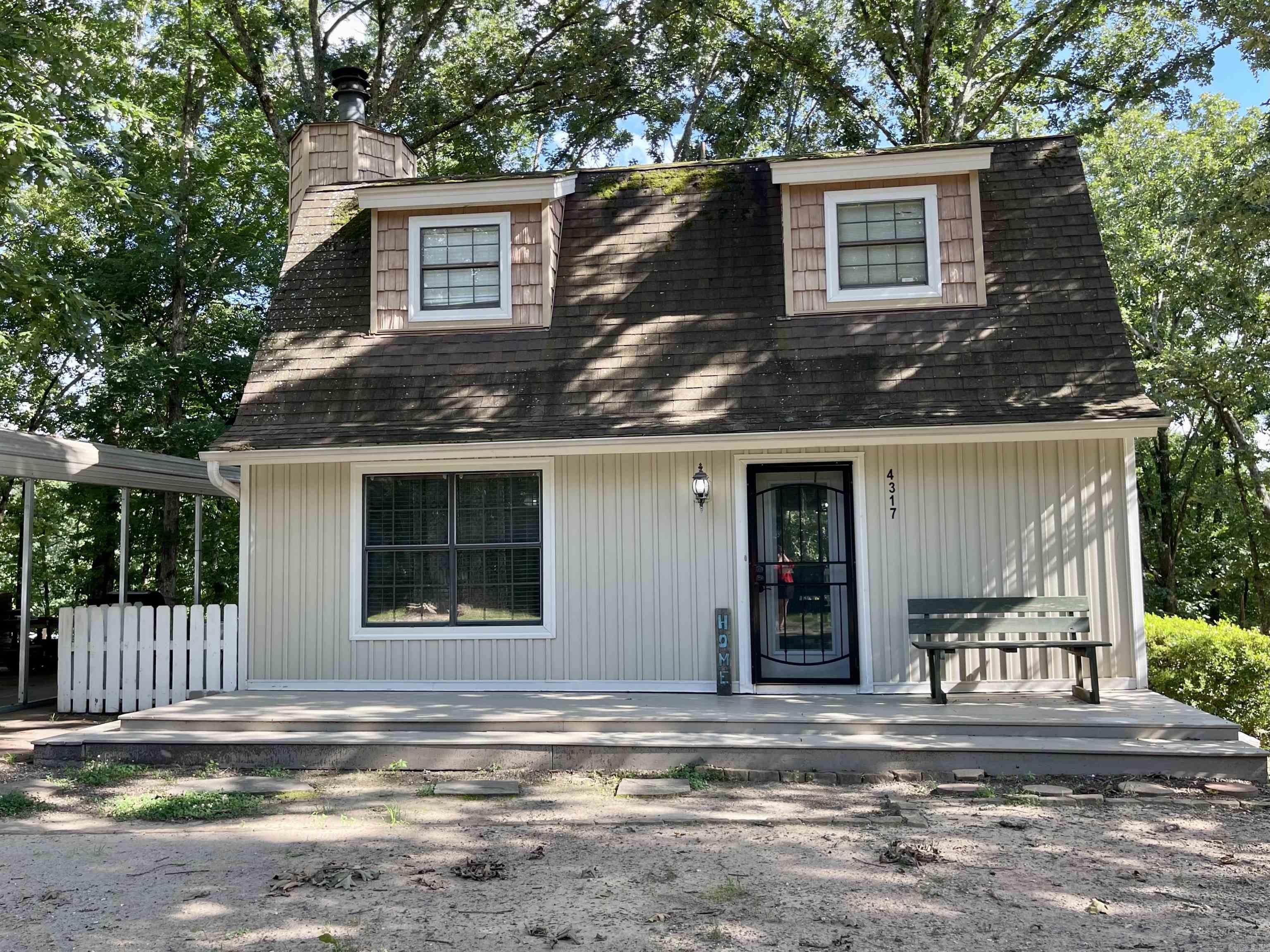 Nestled on a beautiful sloped, wooded lot, this charming two-story home offers 1,212 square feet of comfortable living space with 2 bedrooms and 1.5 baths. Both bedrooms are located upstairs, providing privacy and separation from the main living areas. An additional room on the main floor can be used as a bonus room, office or seperate dining room.    The cozy living room features a wood-burning fireplace, perfect for relaxing evenings, while a large deck overlooks the natural surroundings and provides a great space for entertaining or enjoying the peaceful setting. The home is equipped with four energy-efficient mini-split units for heating and cooling instead of traditional central HVAC.  This property offers tremendous potential and is ready for your personal touch. With some fresh paint and new flooring, you can transform this home into a true woodland retreat. Whether you're looking for a primary residence or an investment opportunity, you'll appreciate the character, setting, and possibilities this home has to offer. Sellers are offering a $5000 flooring and paint allowance.