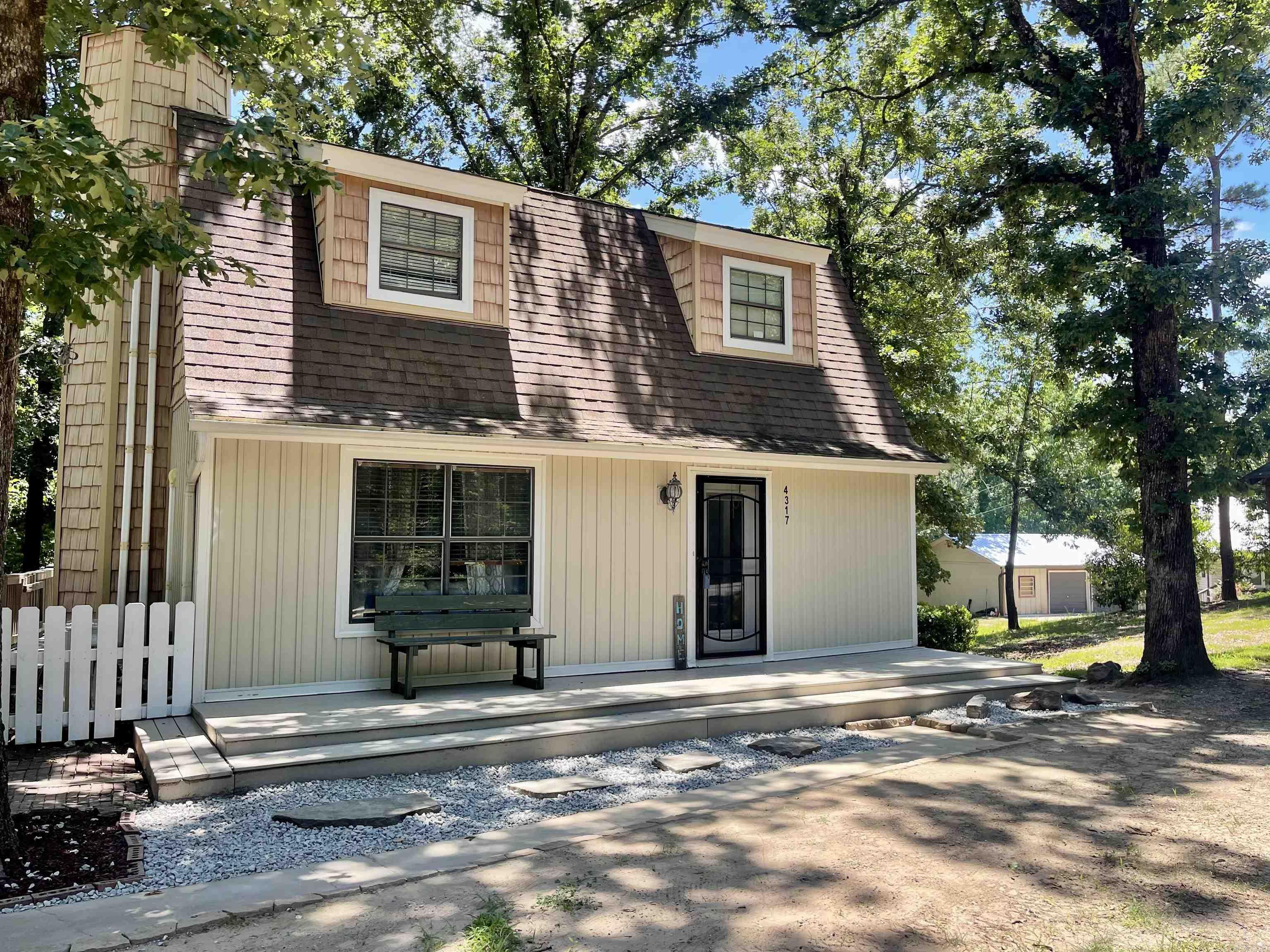 Nestled on a beautiful sloped, wooded lot, this charming two-story home offers 1,212 square feet of comfortable living space with 2 bedrooms and 1.5 baths. Both bedrooms are located upstairs, providing privacy and separation from the main living areas. An additional room on the main floor can be used as a bonus room, office or seperate dining room.    The cozy living room features a wood-burning fireplace, perfect for relaxing evenings, while a large deck overlooks the natural surroundings and provides a great space for entertaining or enjoying the peaceful setting. The home is equipped with four energy-efficient mini-split units for heating and cooling instead of traditional central HVAC.  This property offers tremendous potential and is ready for your personal touch. With some fresh paint and new flooring, you can transform this home into a true woodland retreat. Whether you're looking for a primary residence or an investment opportunity, you'll appreciate the character, setting, and possibilities this home has to offer. Sellers are offering a $5000 flooring and paint allowance.