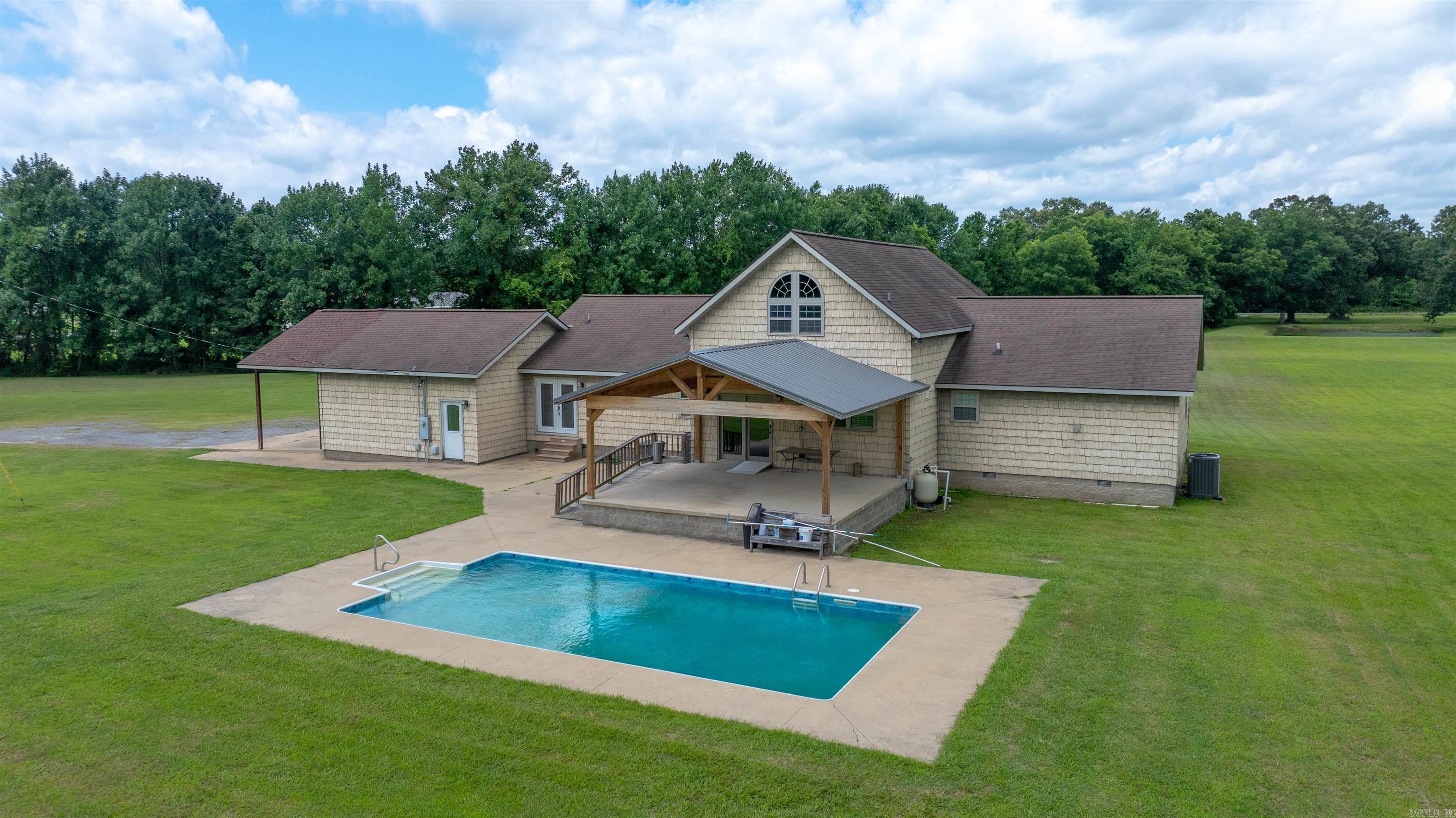 Experience PEACEFUL COUNTRY LIVING on 6.47ACRES m/l just minutes from SOUTHSIDE SCHOOLS. This well-built 3,196 SQ FT home, constructed in 2008 by DEWAYNE HOOKER, features 3 BEDROOMS, 2.5 BATHS, and MULTIPLE BONUS AREAS designed for flexibility. The OPEN-CONCEPT interior is highlighted by TALL CEILINGS, LARGE WINDOWS, and abundant NATURAL LIGHT. An UPDATED KITCHEN offers GRANITE COUNTERTOPS, STAINLESS STEEL APPLIANCES, and CUSTOM CABINETRY, perfect for ENTERTAINING. The MAIN BEDROOM includes a convenient WALK-IN TILED SHOWER. Designed with accessibility in mind, the ENCLOSED GARAGE has been converted into a HANDICAP-ACCESSIBLE BONUS ROOM, and the HALF BATH is also HANDICAP ACCESSIBLE. A versatile LOFT AREA provides the perfect space for an OFFICE, PLAYROOM, or GUEST QUARTERS. Outdoor amenities are equally impressive, featuring a NEWER DECK AND PORCH overlooking the SCENIC ACREAGE.  Enjoy the 16x32 IN-GROUND POOL and a recently added PATIO with a CONCRETE SLAB and PAVILION, creating the ultimate POOLSIDE HANGOUT. This property perfectly balances SPACE, ACCESSIBILITY, and ACREAGE while remaining close to town conveniences. A true MUST-SEE for those seeking room to breathe!