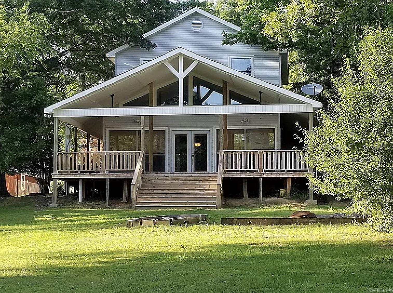 Discover an exceptional lakefront retreat on the north end of Lake Conway, five mins from I-40. Built in 1983 with thoughtful additions in 1992 and 2003, this home blends peaceful daily living and entertaining. It features a bright, open-concept living area and an updated kitchen with granite tile, solid wood cabinetry, stainless appliances, and a large island. Retreat to the sunroom for lake views or unwind in the primary suite with new flooring and a jacuzzi tub. The upper level hosts a standout game room—a true showstopper with domed cedar plank ceilings, a full bar, pool table, and private bath. The exterior offers a fenced 0.6-acre lot, wraparound porch, sunset deck, fire pit, and hydroponic garden. Waterfront amenities include a resurfaced dock and boathouse with a new roof (2025). Added peace of mind: generator wiring and a built-in 6’ x 7’ steel storm shelter in the 3-car garage, which includes a workbench and half-bath.