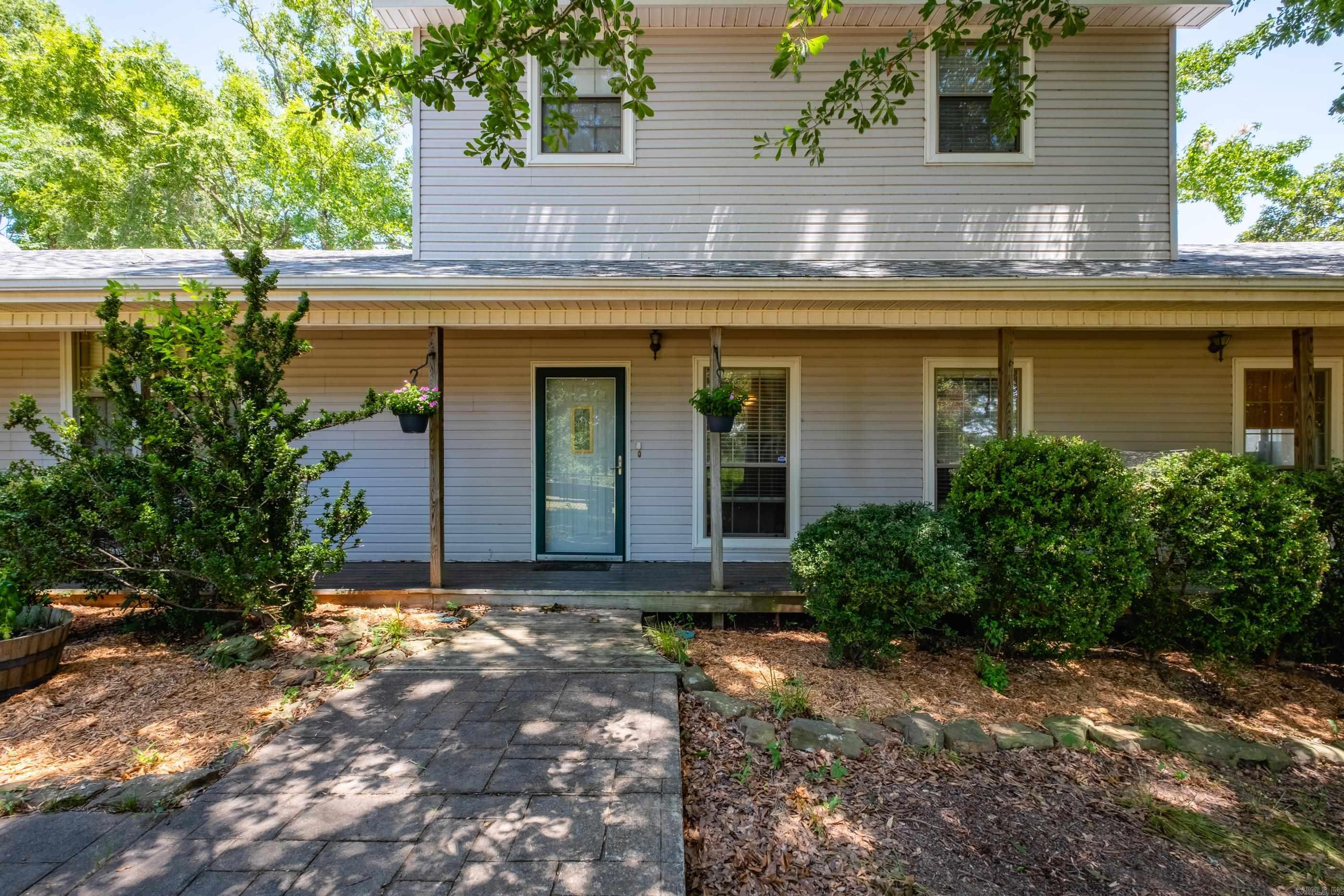 Discover an exceptional lakefront retreat on the north end of Lake Conway, five mins from I-40. Blending peaceful daily living and entertaining, this home features a bright, open-concept living area and an updated kitchen with granite tile, solid wood cabinetry, stainless appliances, and a large island. Retreat to the sunroom for lake views or unwind in the primary suite with new flooring and a jacuzzi tub. The upper level hosts a standout game room—a true showstopper with domed cedar plank ceilings, a full bar, pool table, and private bath. The exterior offers a fenced 0.6-acre lot, wraparound porch, sunset deck, fire pit, and hydroponic garden. Waterfront amenities include a resurfaced dock and boathouse with a new roof (2025). Added peace of mind: generator wiring and a built-in 6’ x 7’ steel storm shelter in the 3-car garage, which includes a workbench and half-bath. See agfc.com for Lake Conway Renovation updates.