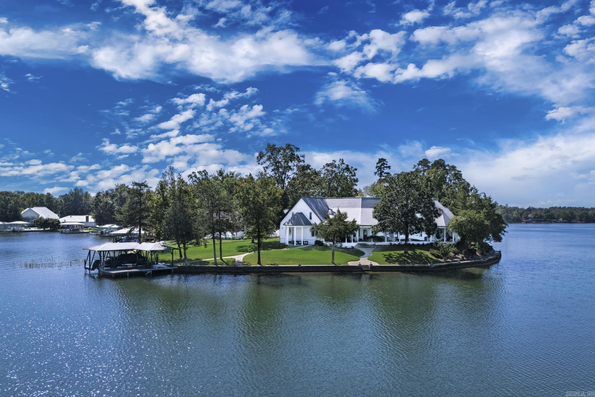 Savor sparkling Lake Balboa views from almost every room at this waterfront retreat. Soaring floor-to-ceiling windows flood the living areas with natural light and frame postcard panoramas, while a covered back veranda invites effortless indoor–outdoor living. A private boat dock puts lake days at your doorstep. The spacious primary suite opens directly to the back patio—perfect for morning coffee or sunset unwinding. Practical perks abound, including a 3-car garage and circle drive for easy parking and guest arrival, and media room for cozy evenings indoors. Thoughtfully designed for relaxing weekends or everyday living, This home blends serene water vistas with comfortable, elegant spaces—your Lake Balboa lifestyle starts here. In addition the lifestyle of Hot Springs Village gated community features golf, hiking, pickleball and beautiful natural scenery.
