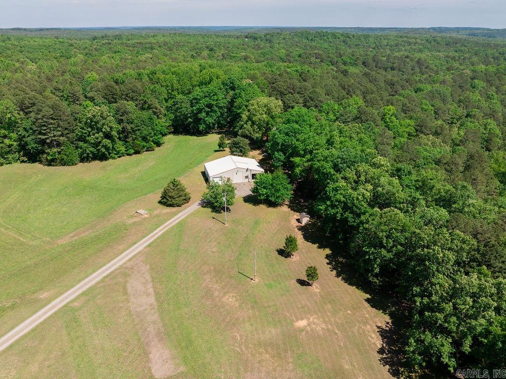 Set on 44 acres between Pangburn and Heber Springs with paved access, this property offers a rare blend of privacy, functionality, and natural beauty just minutes from Greers Ferry Lake and convenient to the world-renowned trout fishing waters of the Little Red River. The land is partially cleared with wooded sections, ideal for livestock, gardening, or future improvements, and features a private pond that adds both scenic charm and recreational use. The 2 bedroom, 2 bathroom barndominium provides comfortable living with a functional layout, including an optional office or small third bedroom and easy-access attic storage. It also features pull-through garage space with two automatic doors and a covered front porch patio overlooking the peaceful wooded setting, making it well suited for full-time living, a weekend retreat, or a hunting base. Additional improvements include a storm shelter, detached outbuildings for storage, and a second septic system already in place for a mobile home or RV, offering flexibility for guests or rental potential. Abundant wildlife such as deer and turkey further enhance this quiet country property. Call your agent today to schedule a tour.