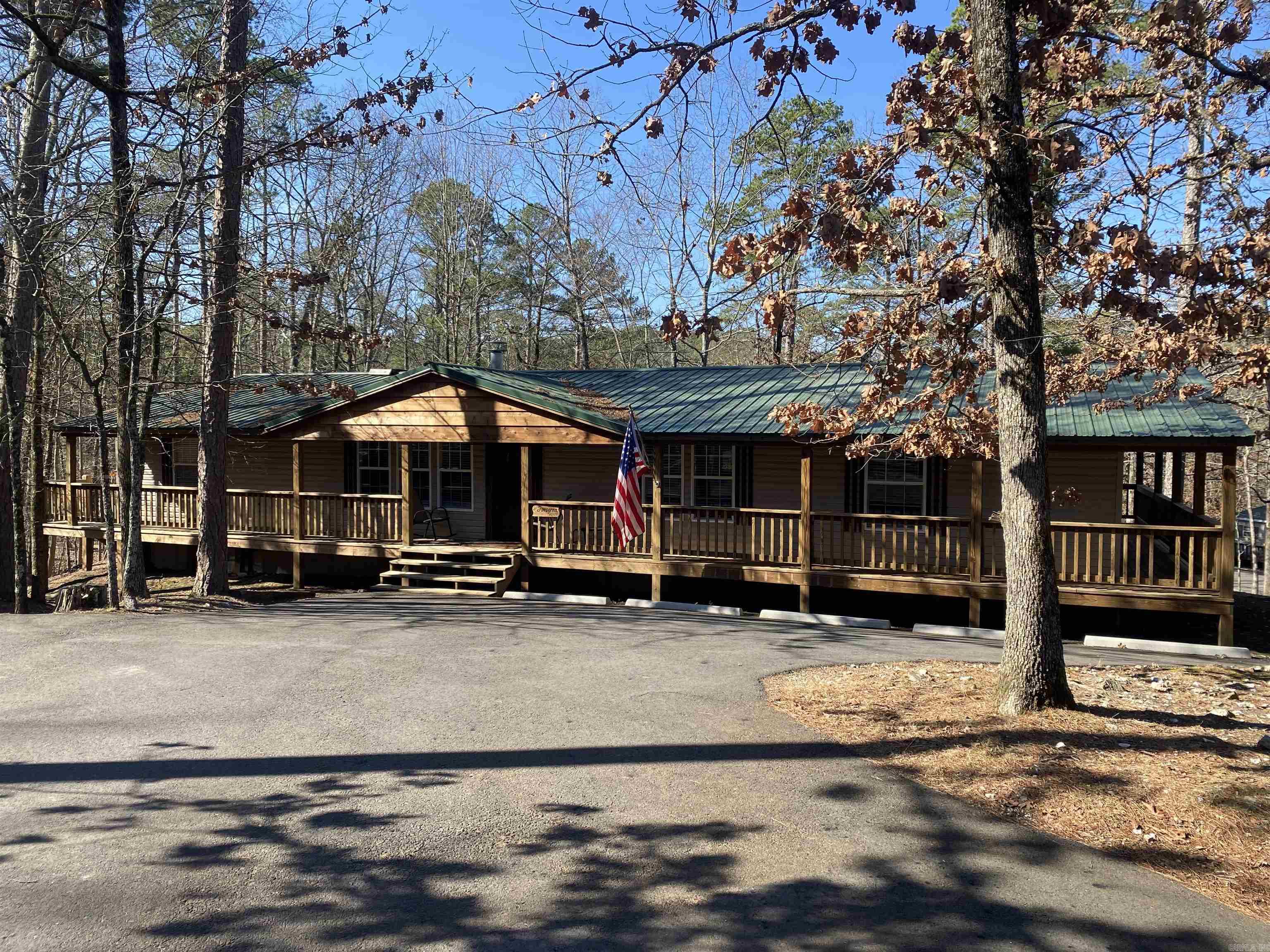 If you have been thinking about your very own place on Lake Ouachita, you do not want to miss seeing this one! Located in the Harbor South neighborhood at Mountain Harbor Resort this 3 bedroom, 2 bath mobile home has approx. 1,728' and sits on .37 acres. Home has been recently remodeled (2021) with new appliances, counter tops, master bath with walk in shower, sheet rock walls, flooring, new fixtures & hardware AND a bonus room that is currently being used as a 4th bedroom. This home features a functional layout and has space for everyone to gather to plan their day. The screened deck off the back has a vaulted ceiling and is a great size for entertaining or just relaxing after a day on the lake. A grilling deck is located off the screened area and is partially covered. Front & back entrances are paved and offer ample parking for everyone.  Whether you are looking for a full time residence or your special lake place this home will check all your boxes. Home is selling fully furnished and is move in ready! Don't wait, call today for your private showing.