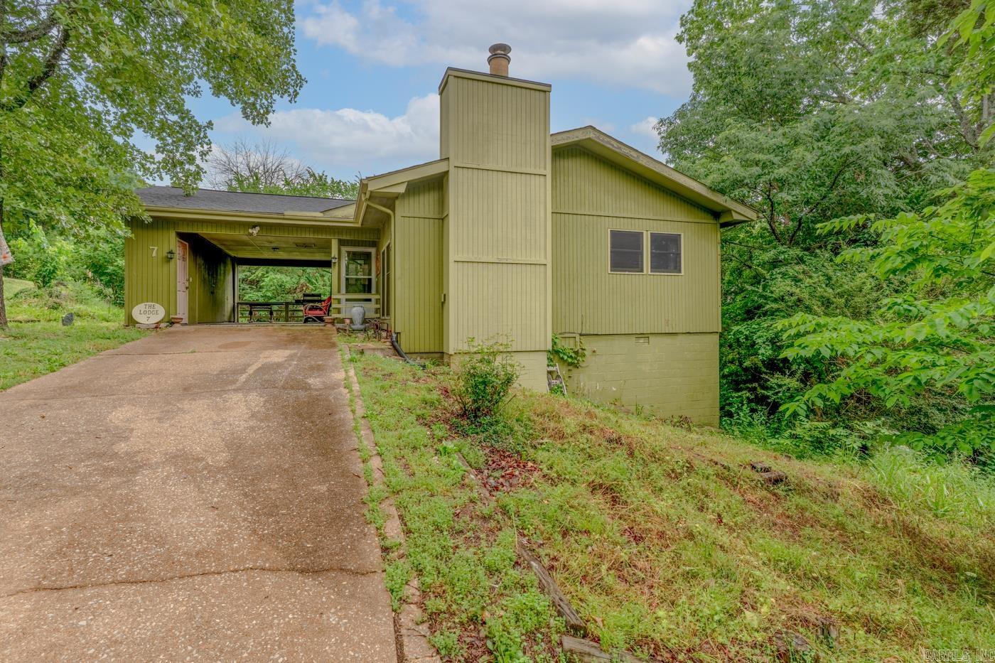 Located in the  Ozark community of Cherokee Village, 7 Cochise Rd offers the perfect blend of charm, space, and potential. This inviting 4-bedroom, 2-bath home features approximately 1,676+ square feet with an open living, kitchen, and dining area designed for comfortable everyday living. A cozy wood-burning fireplace creates a warm gathering space in the retro sunken living room, while the enclosed sun porch and outdoor deck provide the perfect spots to relax and enjoy the natural surroundings.   The walk-out basement adds extra flexibility with an additional bedroom and office area/bedroom, making it ideal for guests, hobbies, or working from home.  New Hvac installed in 2023 along with vinyl plank flooring, furnace in 2022, New Shingled Roof in 2022. Property was inherited and is sold as is Fully Furnished.  Situated on 2 lots,  one lot could go down to the river with clearing, also close to the lakes, golf courses, and amenities that make Cherokee Village so desirable, this property is perfect as a full-time residence, vacation getaway, or investment opportunity. This custom-built home truly shines.